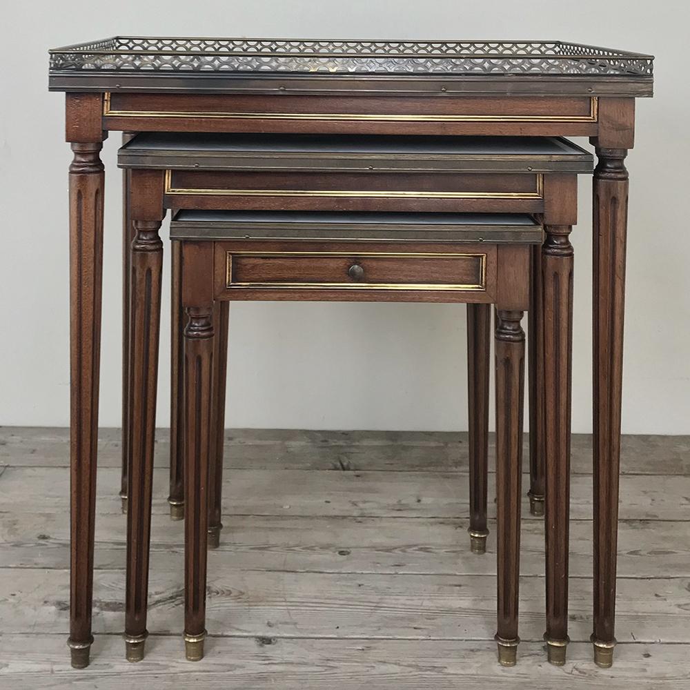 Set of antique Directoire marble top nesting tables are ideal for the formal decor, with beautiful neoclassically designed mahogany combined with Carrara marble and a pierced brass rail. Brass trim and a drawer on the smallest table only add to the