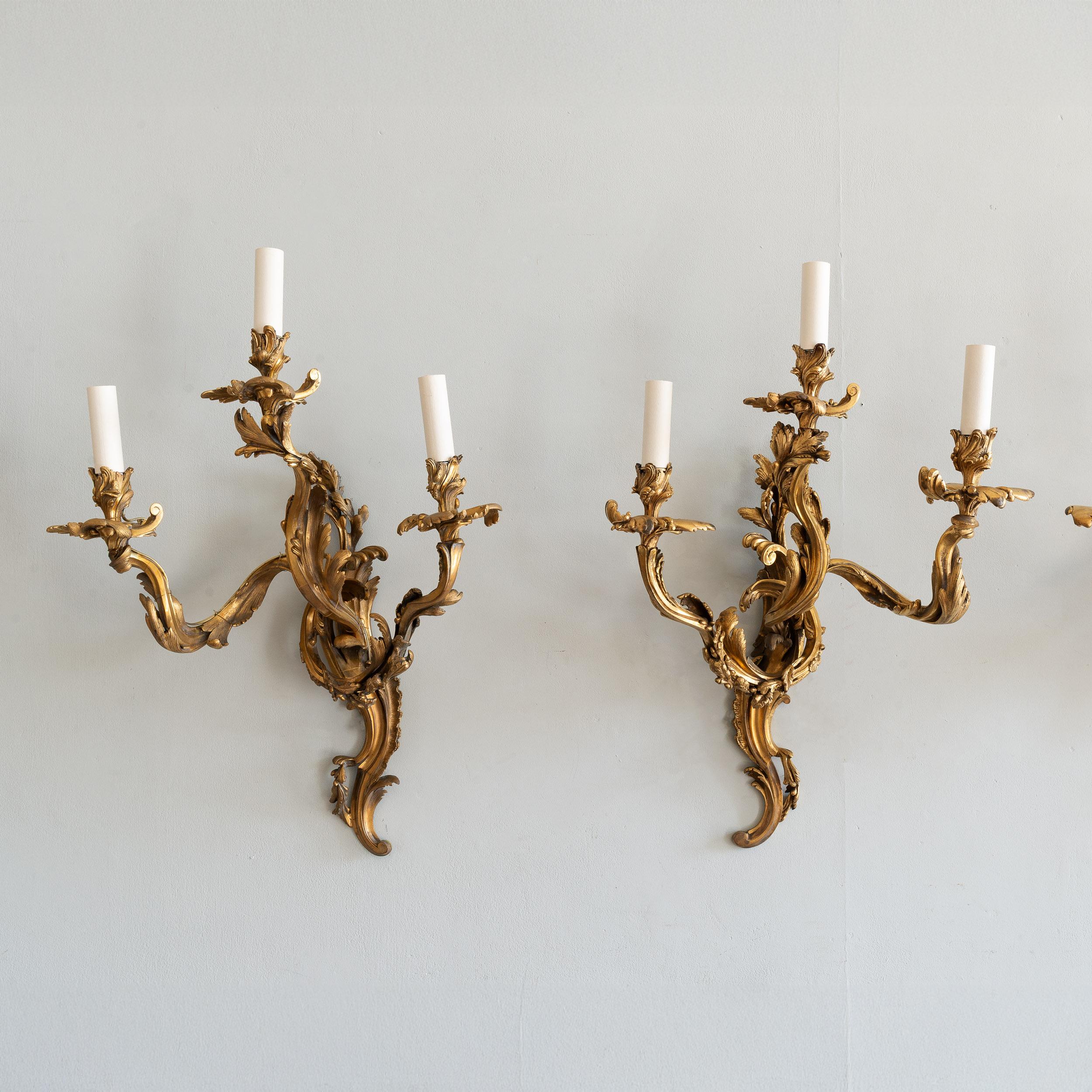 Un ensemble de quatre appliques murales Louis XV en bronze doré du XIXe siècle, de style rococo, recâblées et testées selon la norme PAT. Fonte de qualité de cet élégant design.