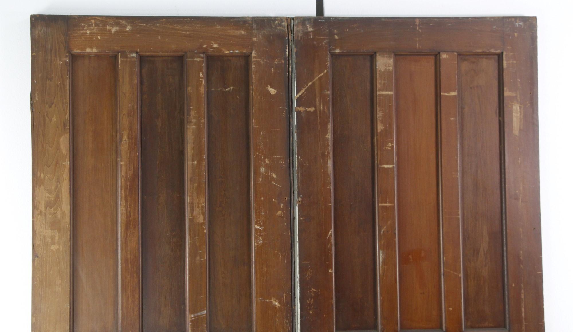 This set of dark tone pine pocket doors are original to the early 1900's have a natural distressed look. Each door of this set has seven panes and measures 32