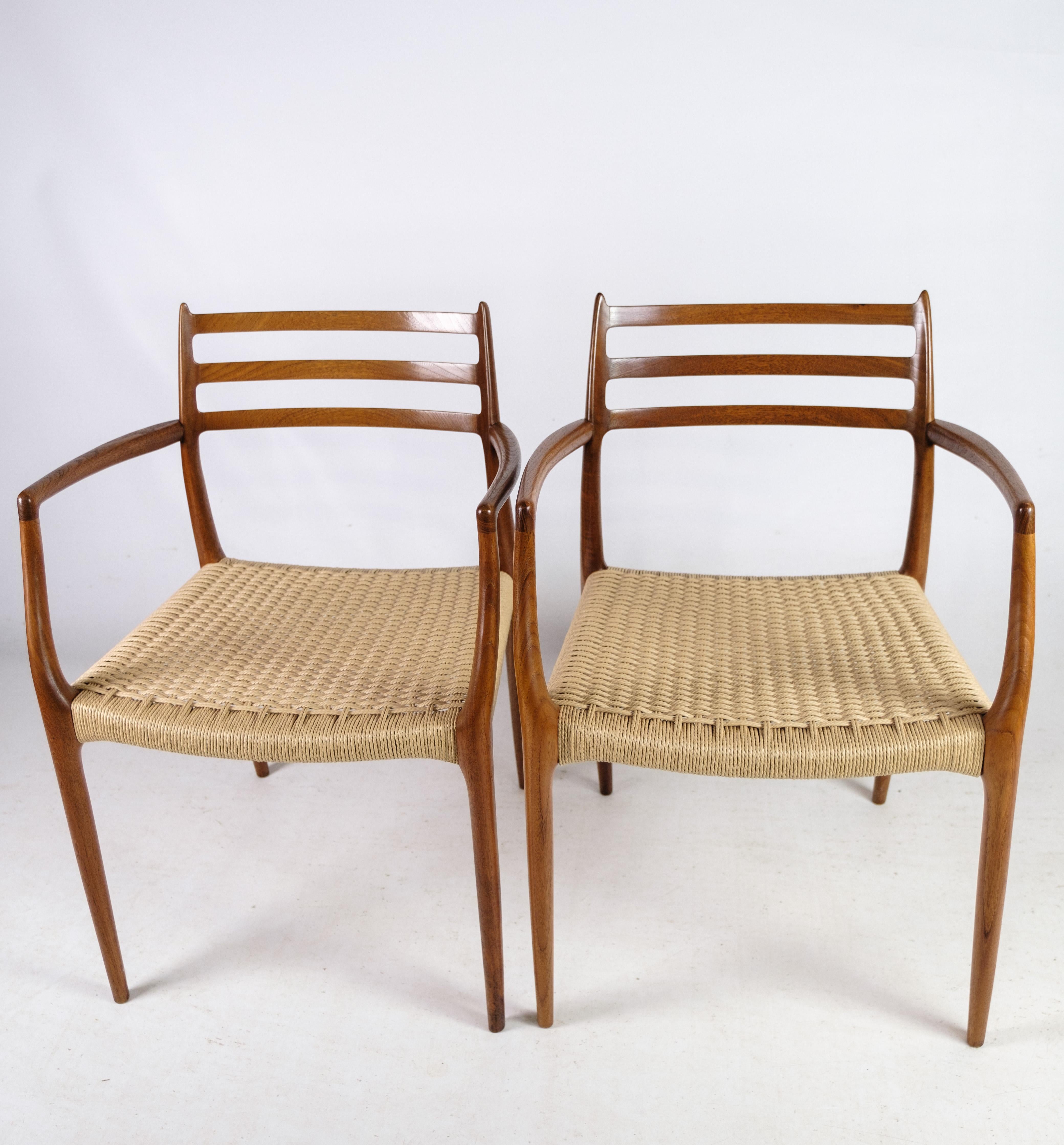 Cet ensemble de deux fauteuils, modèle NO 62, conçu par N.O. Møller en 1962, est une découverte rare et exquise. Fabriqué à I.L.A. Møllers Møbelfabrik, ces chaises témoignent de l'artisanat impeccable et de l'innovation en matière de design de