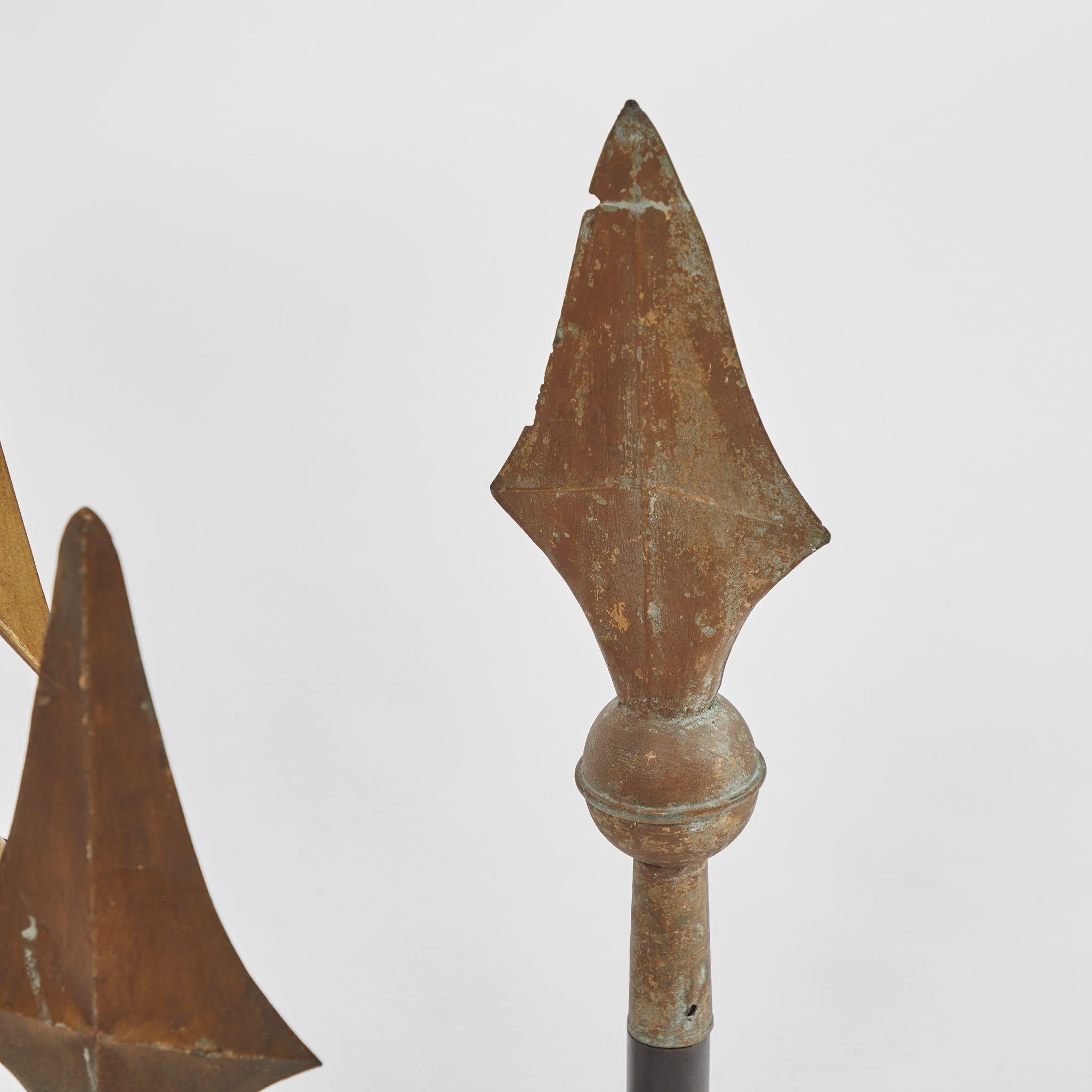 A set of three arrow finials on stands in metal, originating in England, circa 1900.