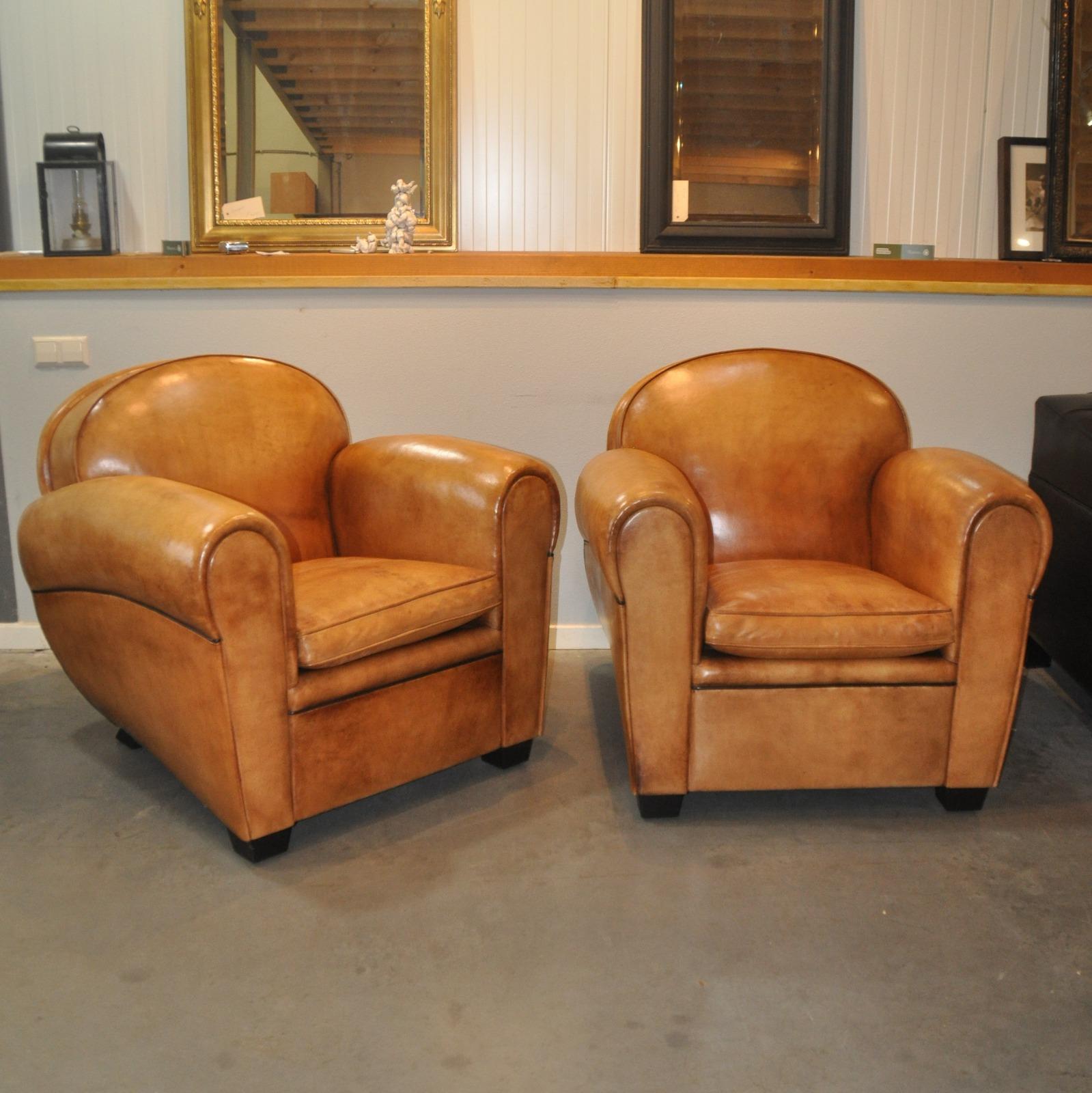 Set of Two Art Deco style armchairs and hocker by Bart van Bekhoven Model 'Witlam' in Sheep Leather from the Netherlands 1970s. These armchairs in Art Deco style are finished with black and colored piping. Loose seat cushion. The set is in new