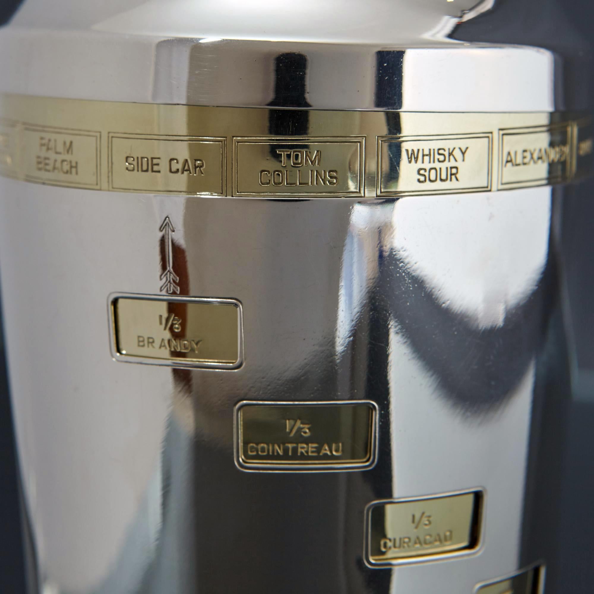 Art Deco style American recipe cocktail shaker with silver-plated sleeve and gold-plated body, engraved around with the recipes for numerous classic cocktails: Sidecar, Tom Collins, Whisky Sour, Alexander, Bacardi, Between the Sheets, Bronx, Clover