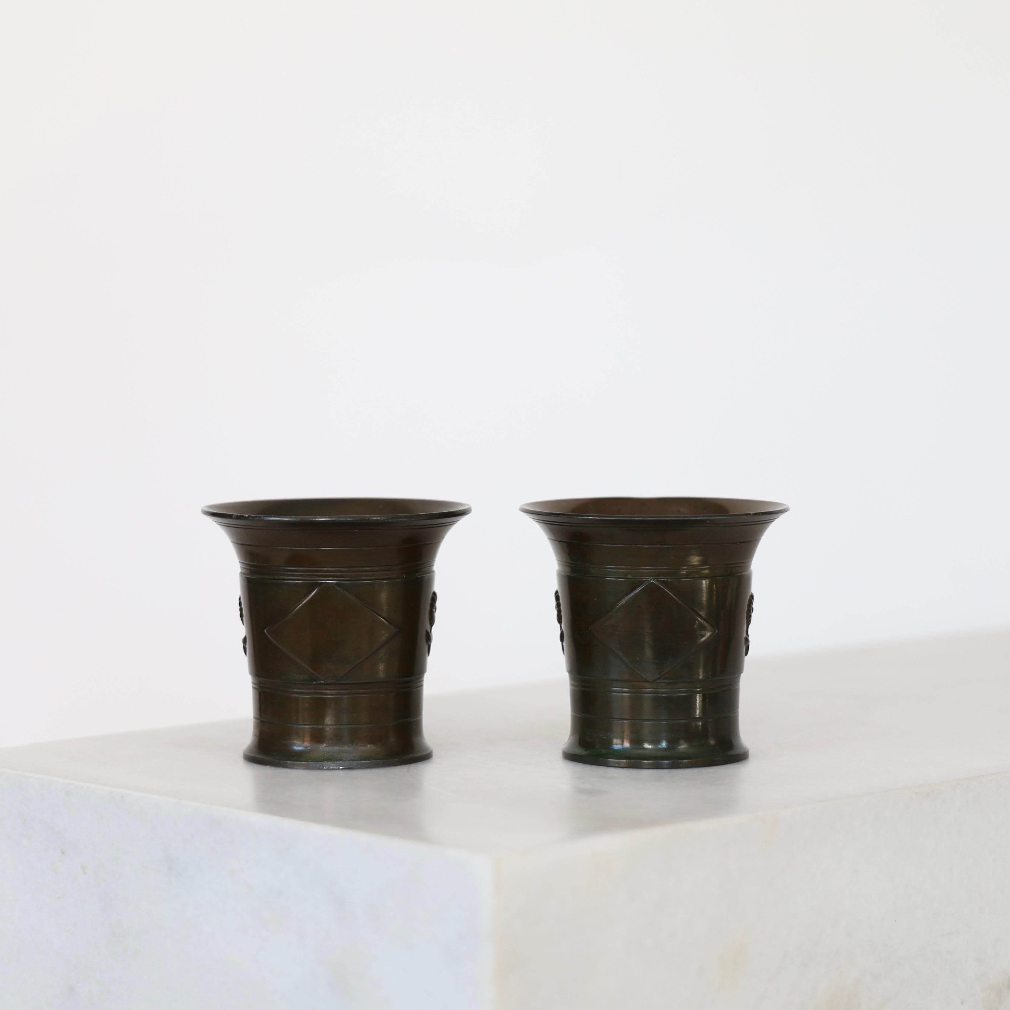 Set di calici Art Deco realizzati da Just Andersen negli anni Venti. Un bel duo per un posto bellissimo.

* Set (2) di calici / vasi rotondi in metallo con ornamenti floreali  
* Designer: Just Andersen
* Stile: D107 
* Anno: 1918-1929
* Condizioni: