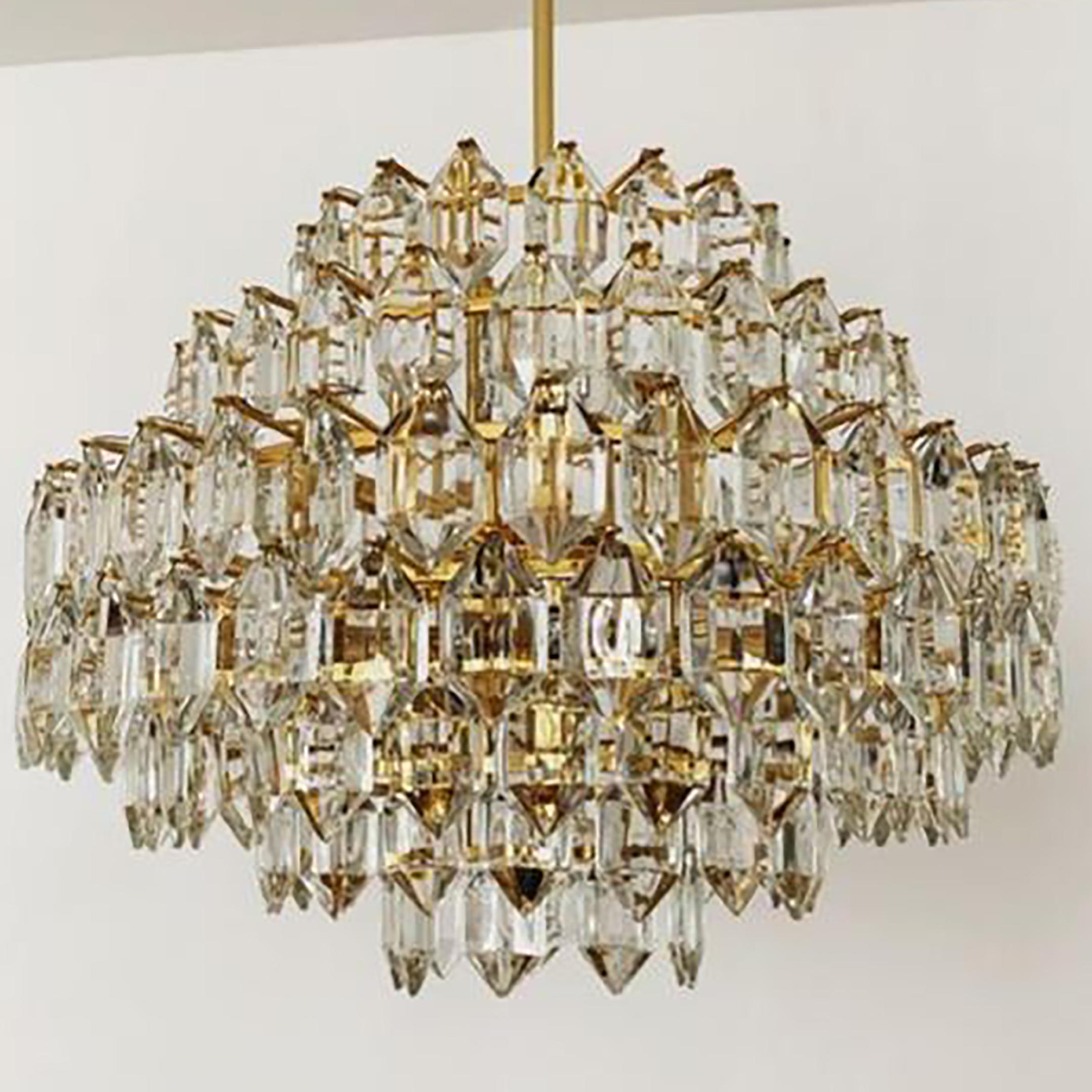 A set of elegant light fixtures by Bakalowits & Sohne, Austria. The chandelier and 2 wall lights are manufactured in circa 1960-1969. With huge gem-like crystals and gilded brass frame. The crystals are meticulously cut in such a way that radiate