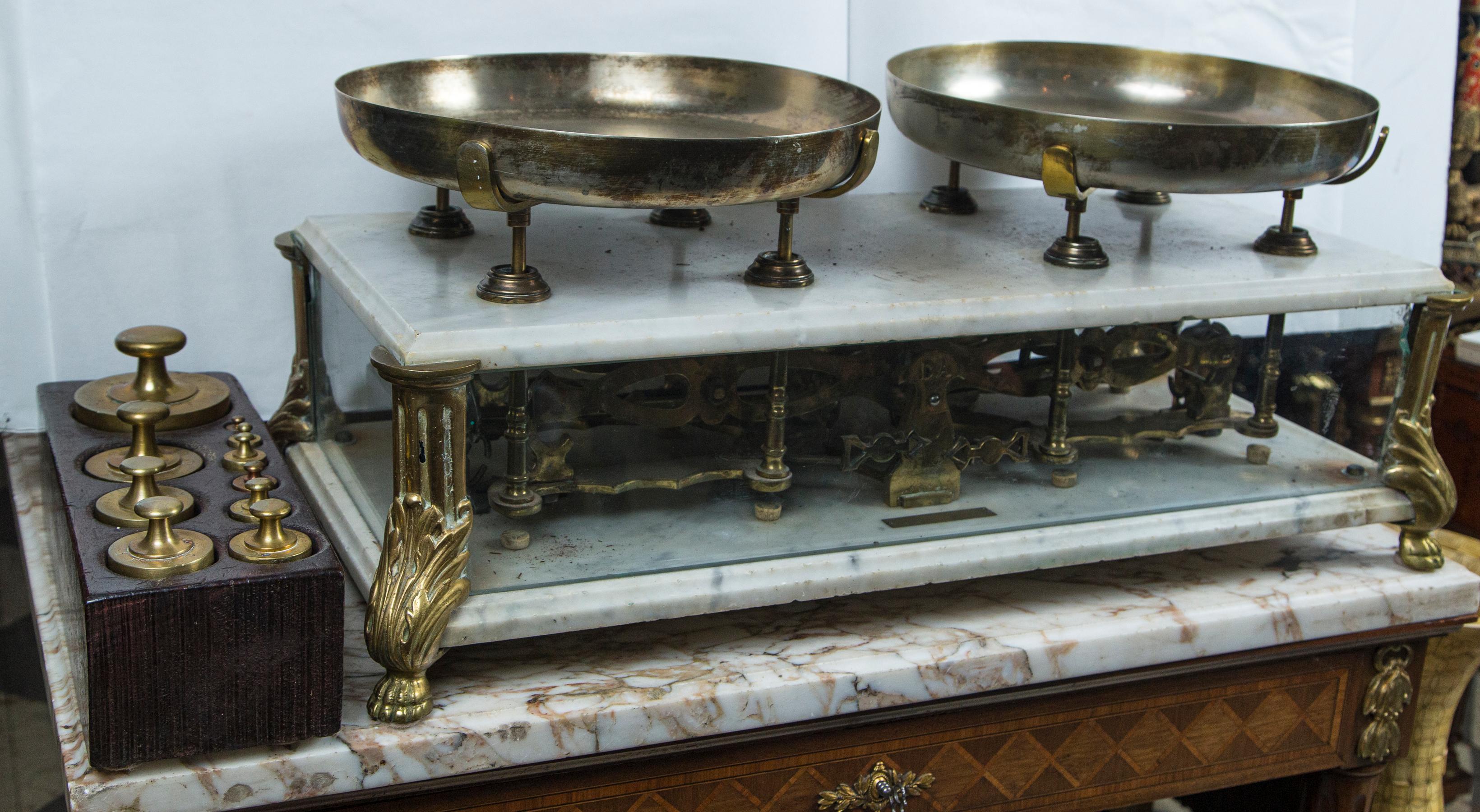 Marble top and base, bronze legs, glass sides, and brass weight pans. The workings visible thru the glass. The back and one glass on the side are missing, there is an engraved plaque on the front side, within the case that reads DOMINICO ARCIELLO,
