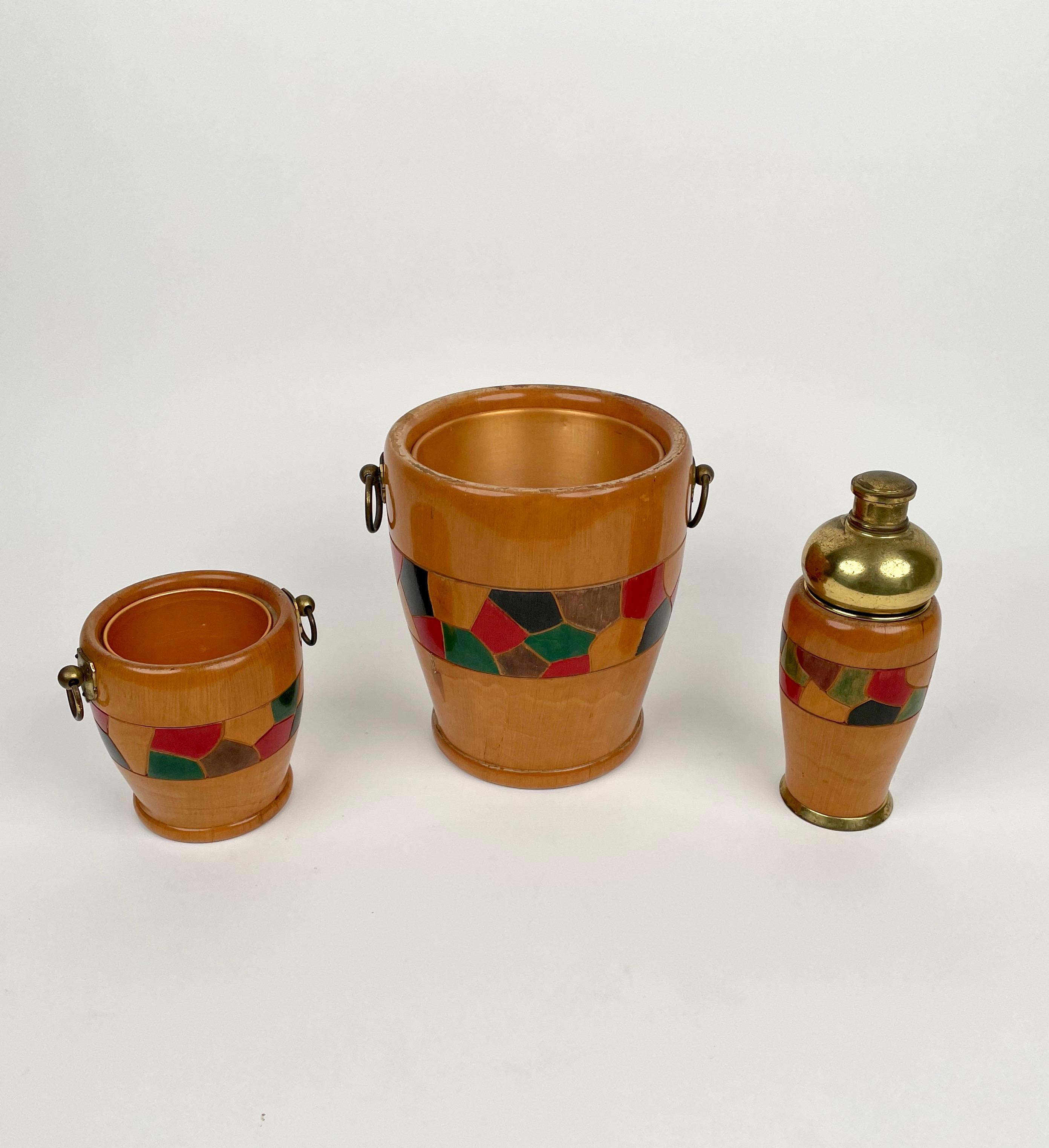 Barware set by Aldo Tura comprising of two ice buckets of different dimensional and a shake, all in hand-carved wood with brass details. Made in Italy in the 1950s. 

Dimensions:
- Big ice bucket: 21cm diameter, 24cm height 
- Small ice bucket: