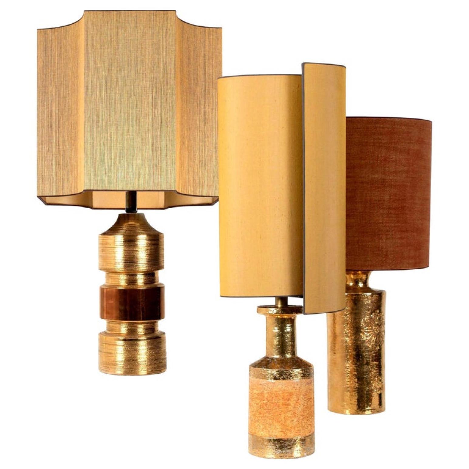 Exceptional set Bitossi lamps with a ceramic base with shiny metallic gold glaze. Bitossi for Bergboms, Italy, circa 1960s. With an exceptional custom made shades by René Houben. With warm gold inner-shade.

Approximate dimensions:
Lamp ceramic only