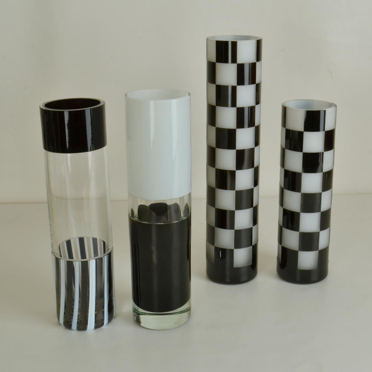Set of four hand blown tubular vases in black & white in alternating heights. Two are etched in a checker pattern, revealing the contrast colors. The other two are build from different sections melted onto each other. 

Individual heights;
