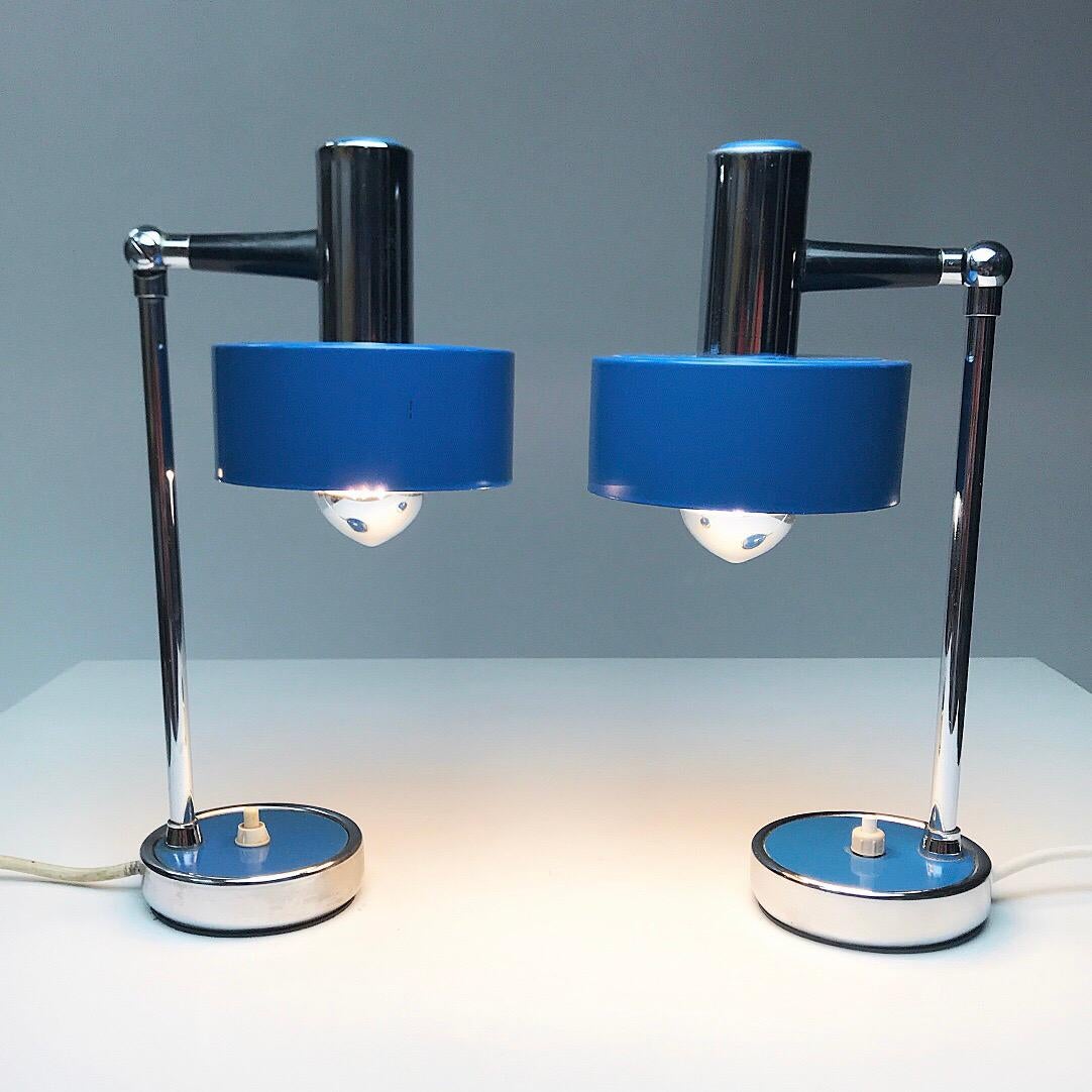A set of two blue lacquered table lamps made in Italy, 1960s, attributed to Stinovo.

Chrome stem, blue lacquered metal and black plastic details leads from the stem through the joint and out to the shade. The joint can be adjusted as shown on the