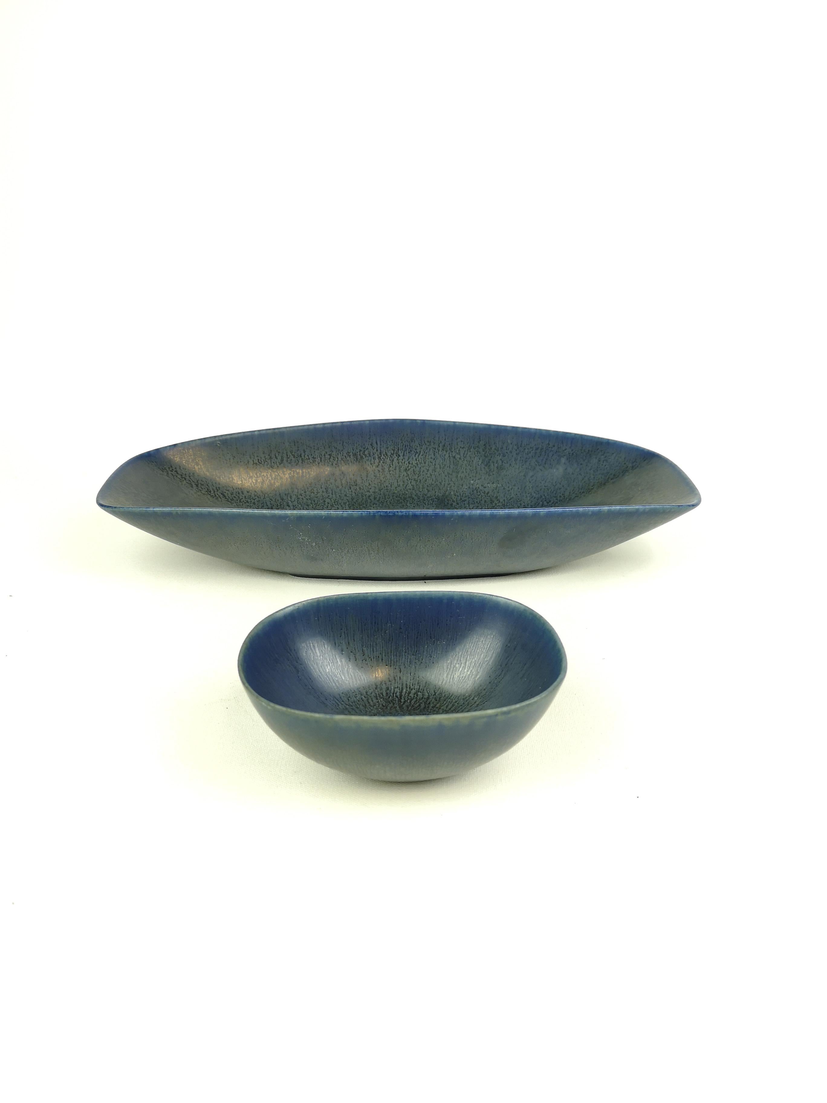 A set of 2 bowls produced in Sweden at Rörstrand and designed by Carl-Harry Stålhane in the 1960s. Beautiful created bowls with a wonderful blue glaze.

Measures: Large bowl 31/14/6 cm, small bowl 12/9/5 cm. 

Both are in very good condition.
 