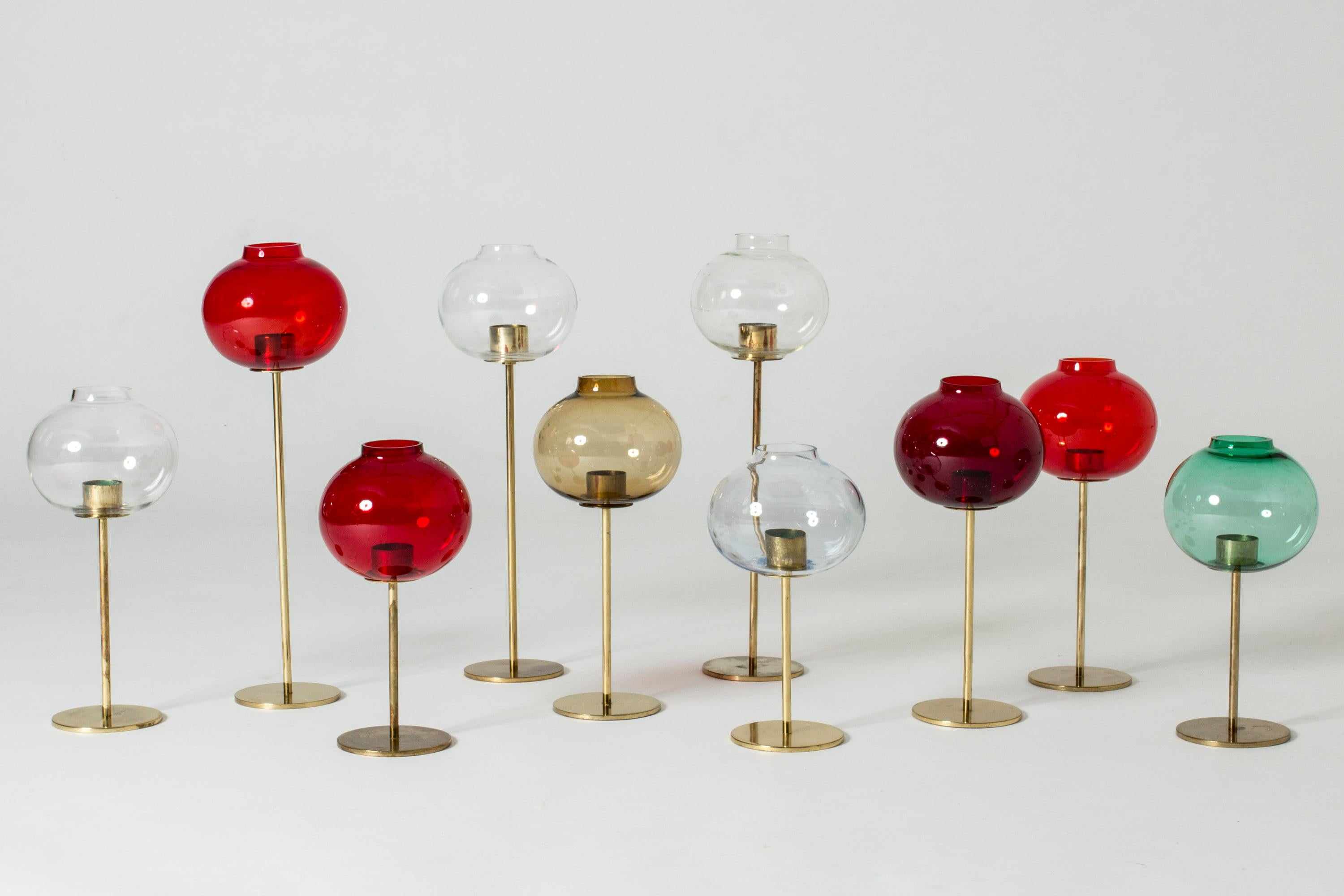 Set of ten brass and glass candleholders by Hans-Agne Jakobsson. Cool play between the slender stems and bulbous glass shades. Red, clear, smoke, pale blue and green colored shades. Fit thick candles.

Size: Height 26-44 cm, diameter 13 cm.