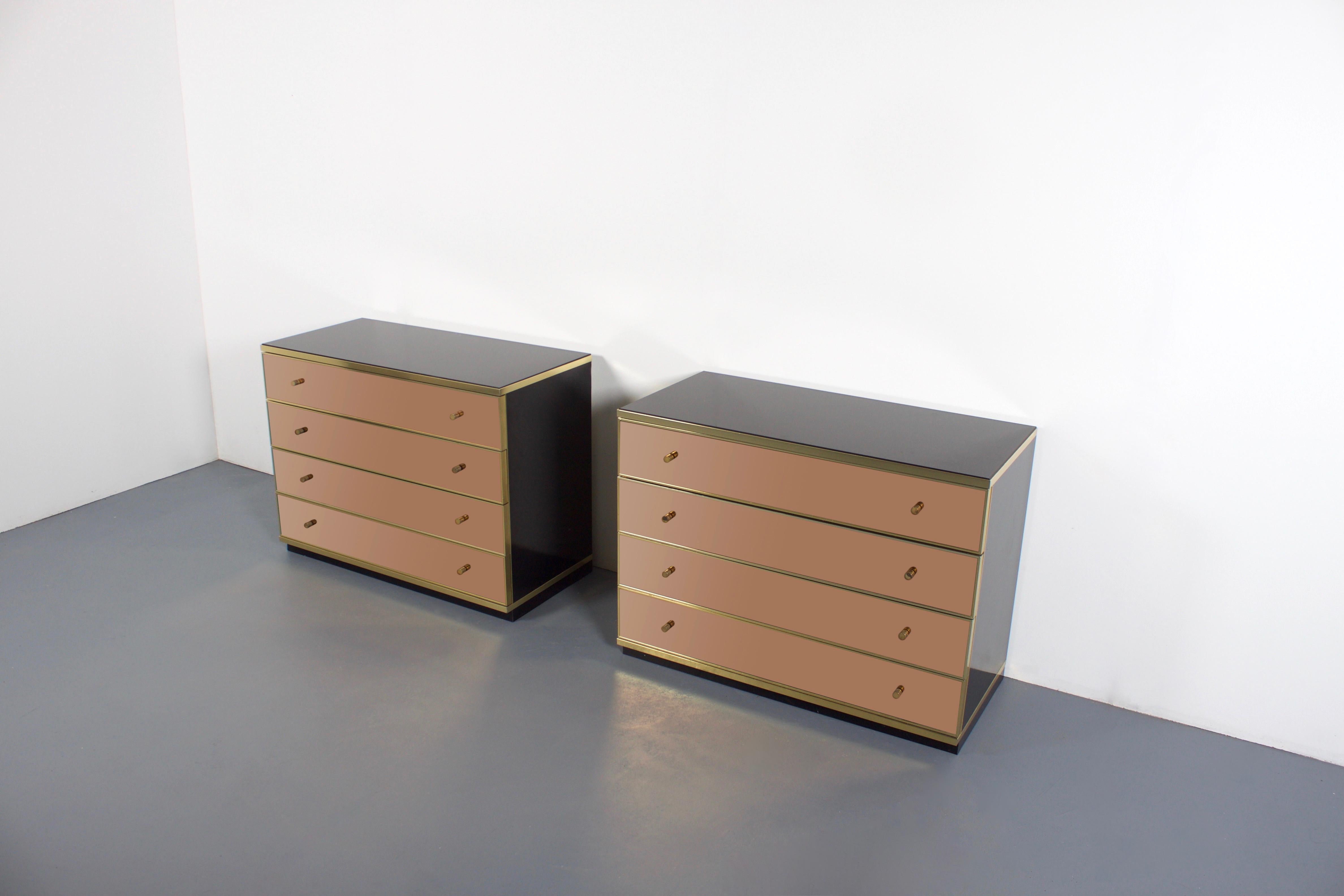 Two stunning Italian metal arte sideboards in very good condition.

Designed by Renato Zevi in the 1970s

The sideboards have a glossy black glass top and lacquered black side panels
with brass details.

The four drawers have gold mirrored glass