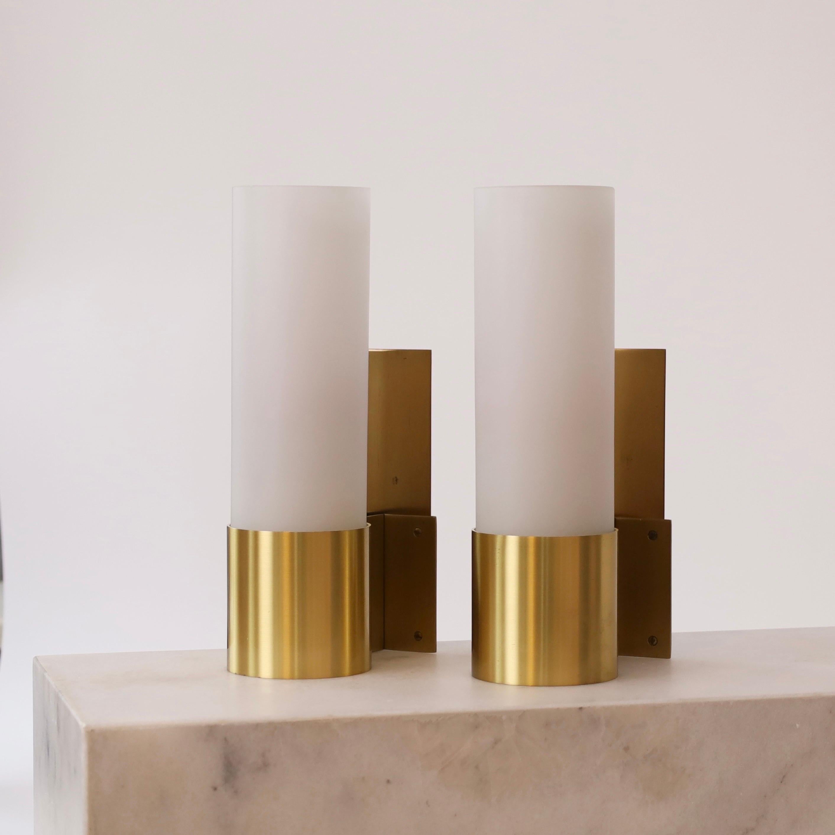 Rare set of Brass & Opaline glass sconces in great condition designed by Jørgen Bo for Fog & Mørup in 1968. A classic touch to a beautiful home. 

* A pair (2) of brass sconces with white mouth-blown Opaline shades
* Designer: Jørgen Bo
* Model: