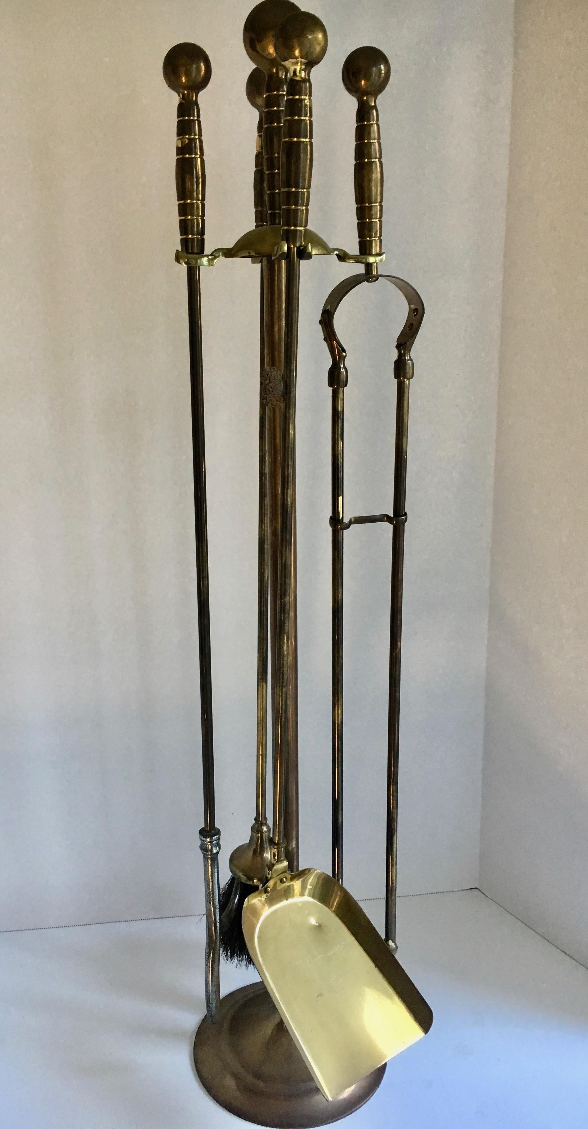 Set of brass fireplace tools on stand - broom, tongs, shovel and poker on a stand. Perfect for any fireplace setting, from cabin to traditional or modern home.
