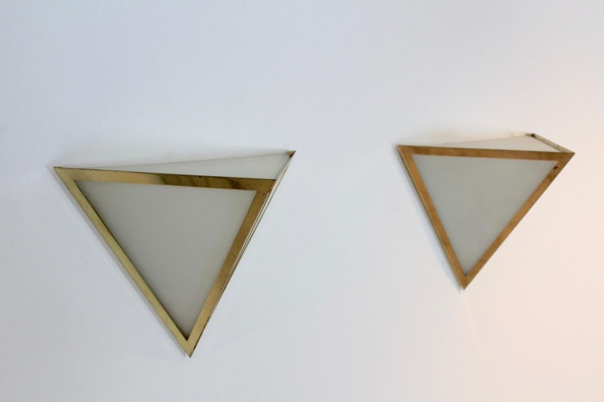 Very beautiful and characteristic set of large brass and opal glass 3880 wall lamps produced in Germany by Glashütte Limburg in the 1970s. Each lamp has a large and very solid triangle opal glass base surrounded with a handsome brass triangle frame.