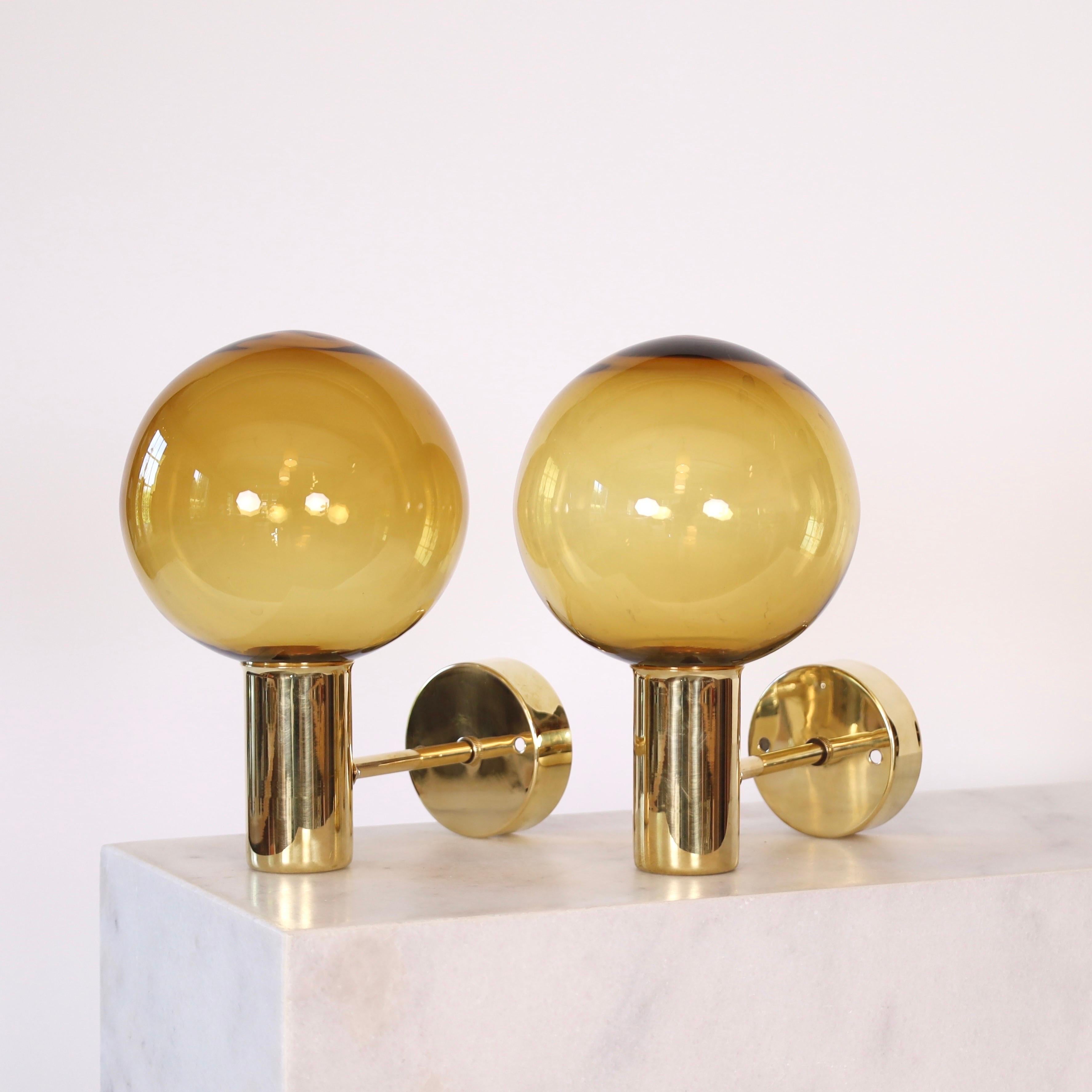 Set of Brass Sconces with Golden Brown Glass shades made by Hans-Agne Jakobsson in the 1960s. A classic set for a beautiful home. 

* Pair (2) of brass sconces with golden-brown glass shades
* Designer: Hans-Agne Jakobsson
* Model: V49 (Patricia)
*
