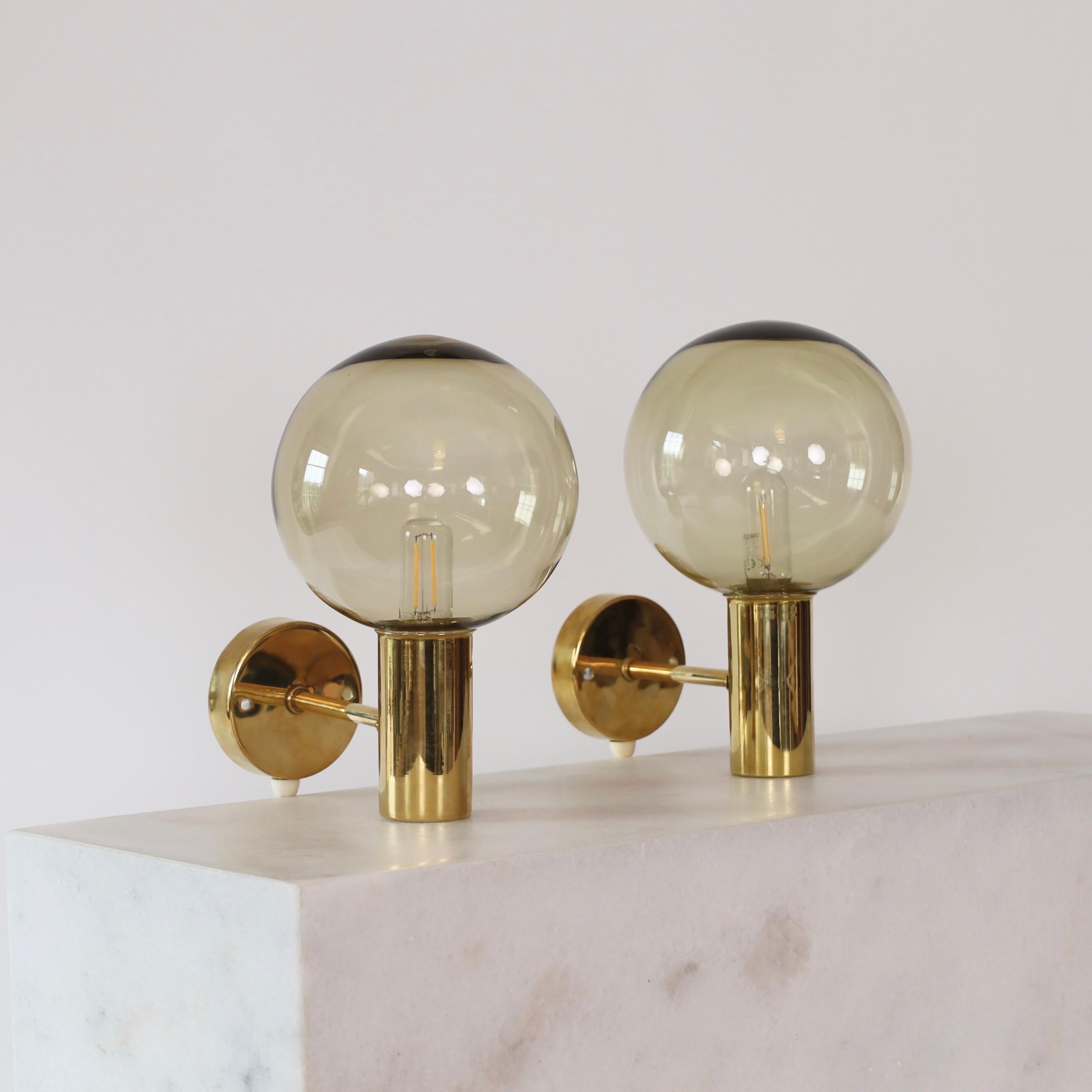 Set of Brass Sconces with Smokey-Brown Glass shades made by Hans-Agne Jakobsson in the 1960s. A classic set for a beautiful home. 

* Pair (2) of brass sconces with smokey-brown glass shades
* Designer: Hans-Agne Jakobsson
* Model: V149 (Patricia)
*