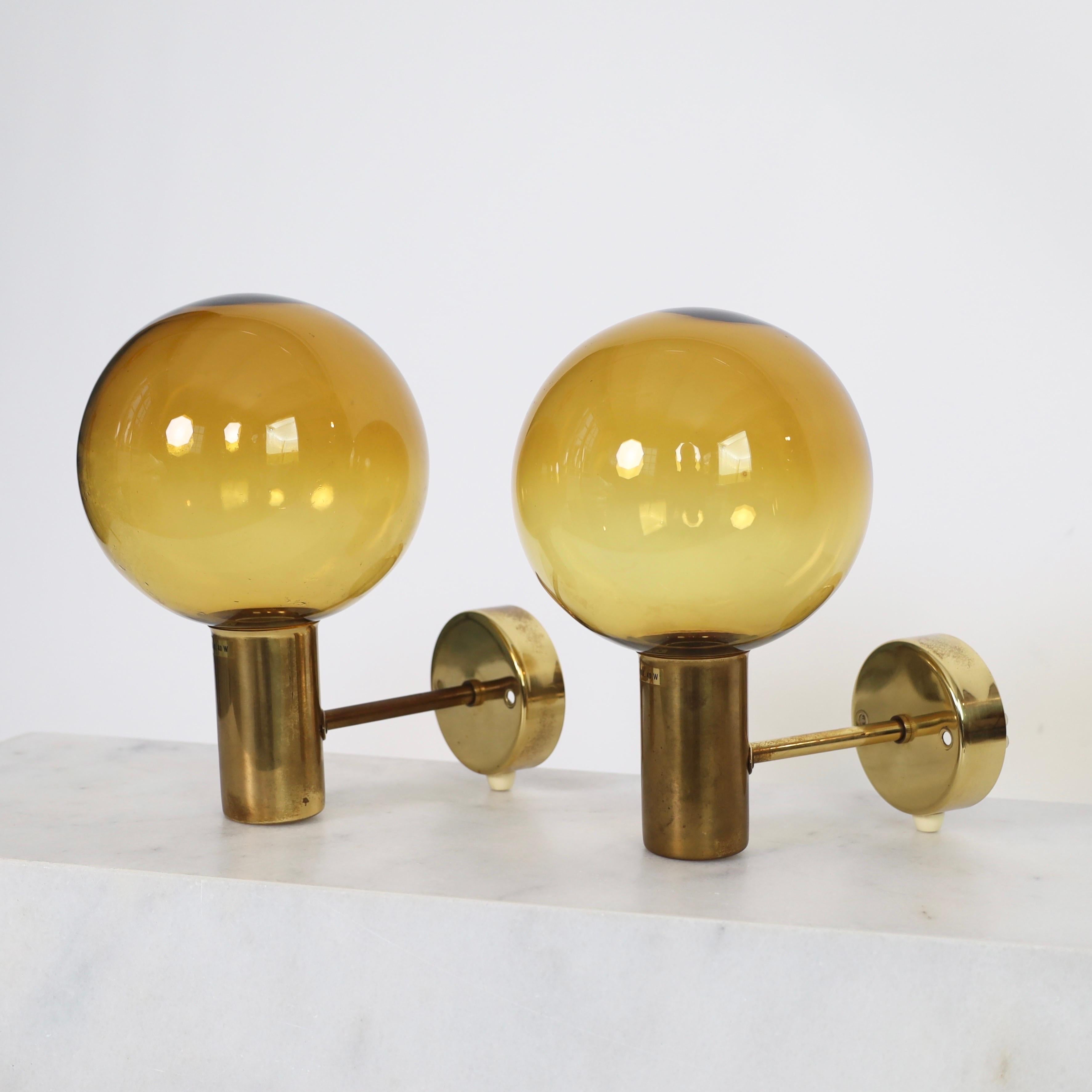 Ensemble d'appliques en laiton avec abat-jour en verre brun doré réalisées par Hans-Agne Agnes dans les années 1960. Un ensemble classique pour une belle maison. 

* Paire (2) d'appliques en laiton avec abat-jour en verre brun doré
* Designer :