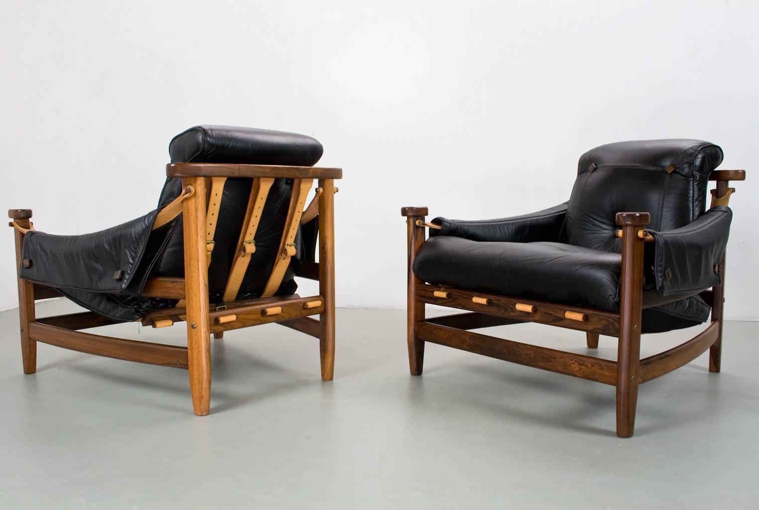Brazilian modern yet almost brutalist design with great attention for detail, this set of 'Bertioga' lounge chairs was designed by Jean Gillon in the 60s and they are truly an eye catcher in any home. The black leather is beautifully stitched and in