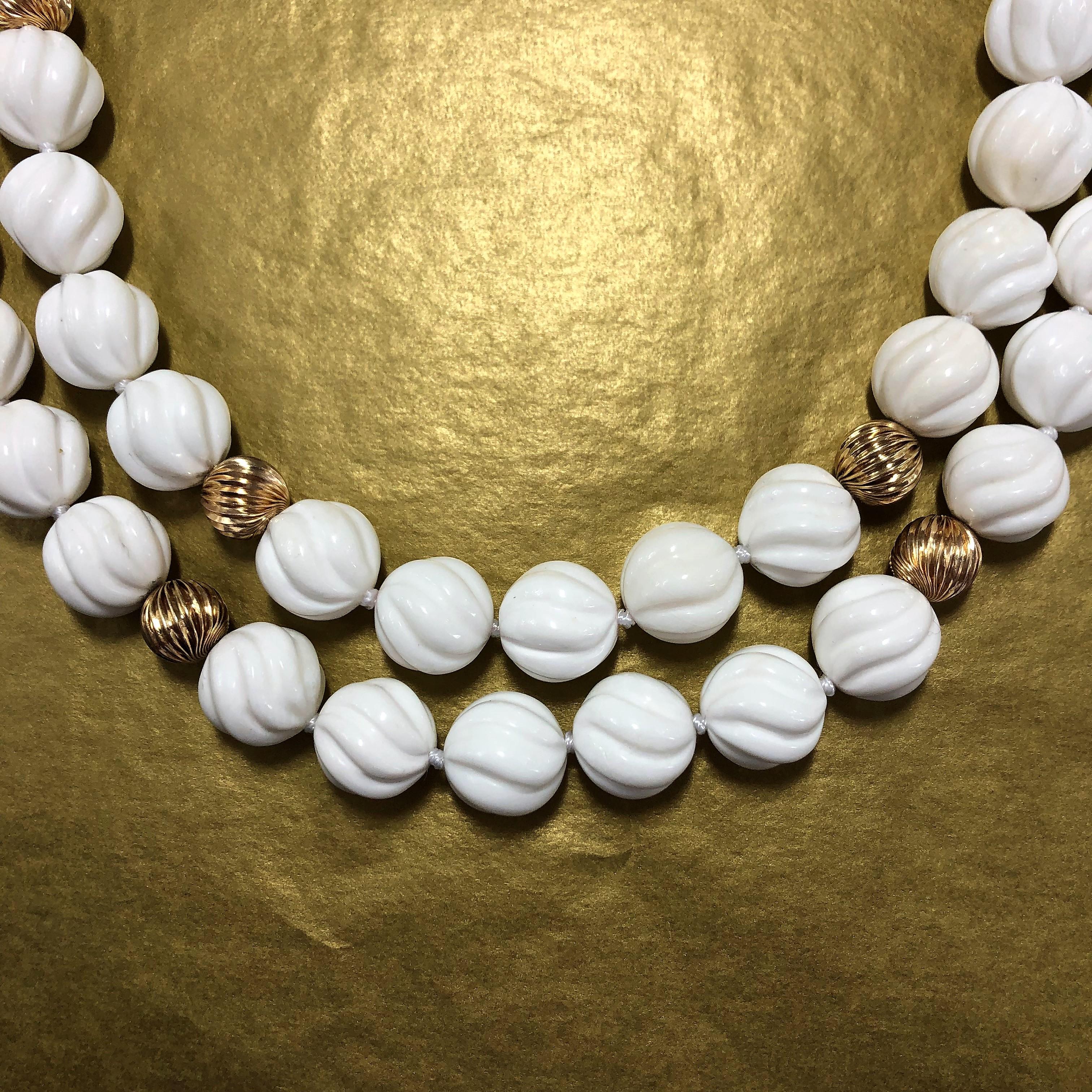 A wonderful set of bright white spiral design, shell beads with 14k Yellow Gold bead accents
and clasps. When the two clasps are aligned in the back, the set nests beautifully on the neck.
The inner strand measures 18 1/2 inches long by 5/8 inch