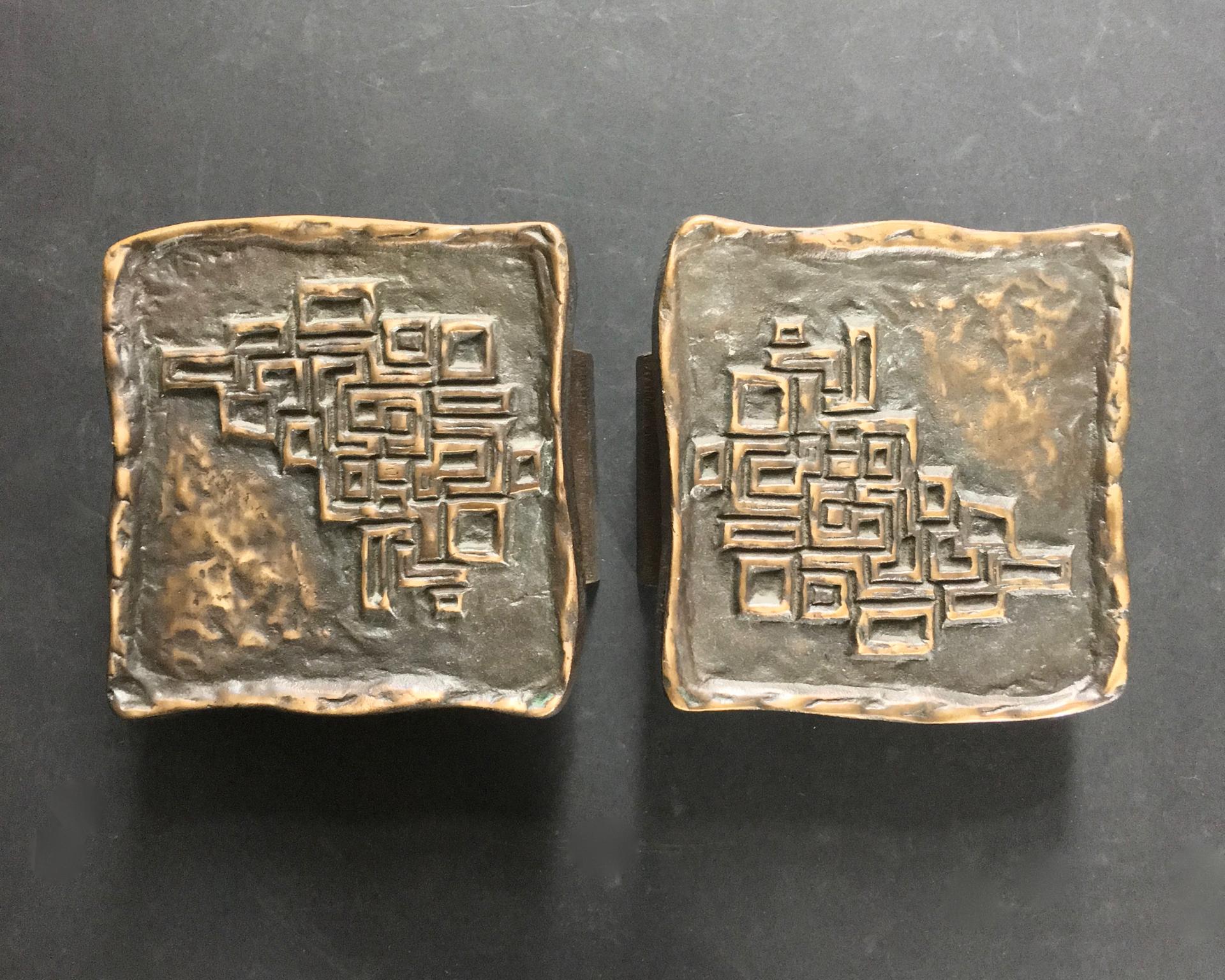 Set of two large bronze door handles of rectangular form with raised abstract design. European, probably 1970s.

These are heavy pieces, made of cast bronze with deep reddish-brown tones, which could suit both interior and exterior doors. The two