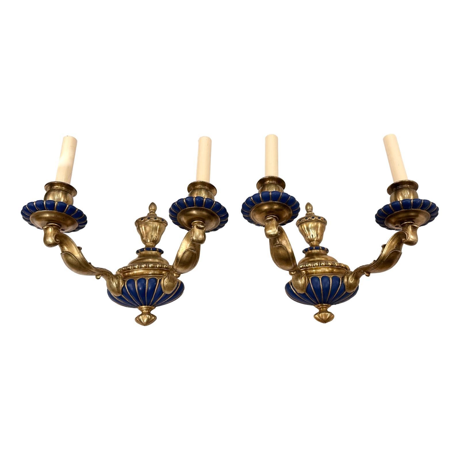 Un set di otto appliques in stile neoclassico inglese degli anni '40 circa, in bronzo dorato con dettagli in blu. Venduto al paio.

Misure
Altezza: 11
