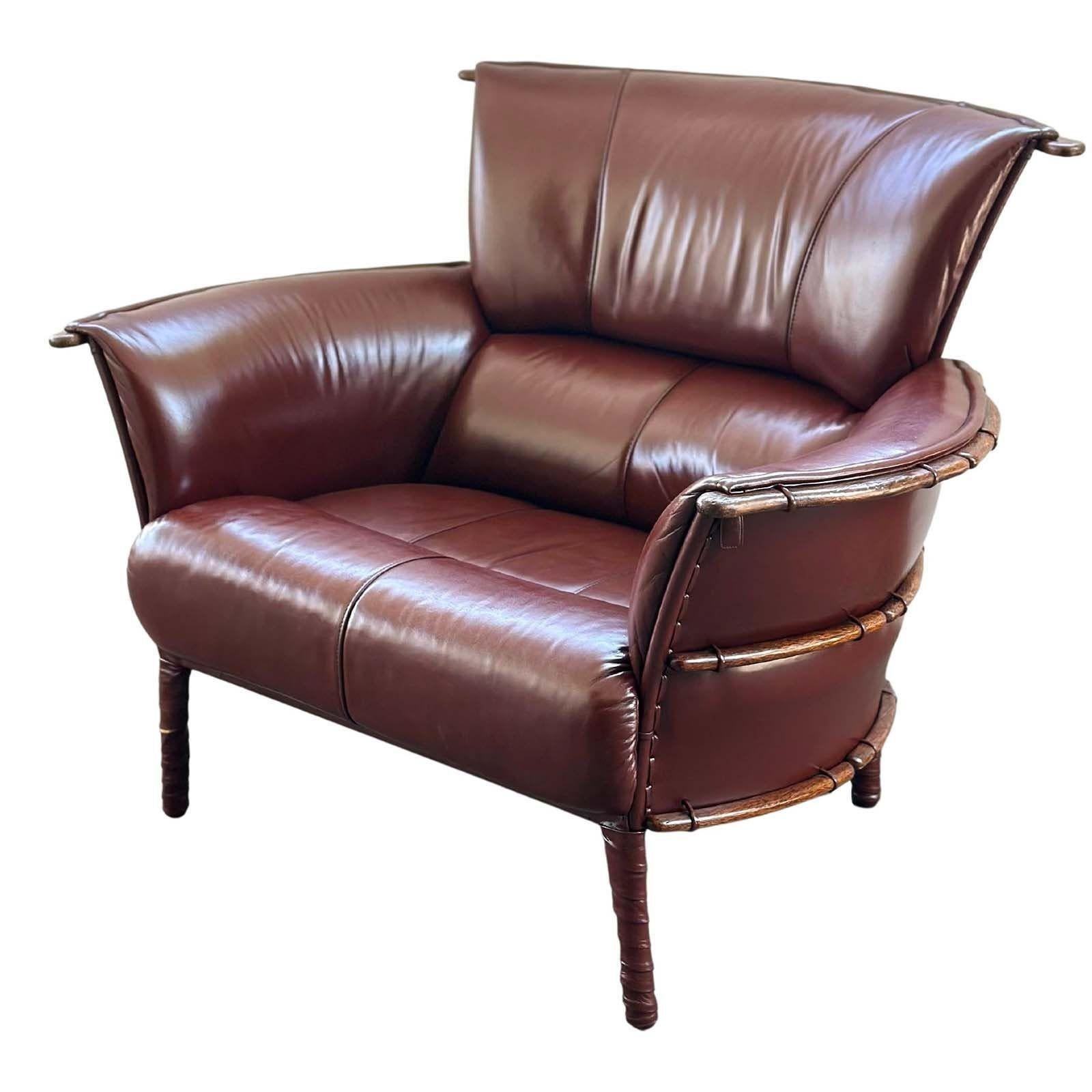 Versatile and stylish set of burgundy leather armchair and ottoman by Pacific Green. The leather has been newly reconditioned and the back of the frame is wrapped around palm wood ribs.
From Pacific Green Website:

