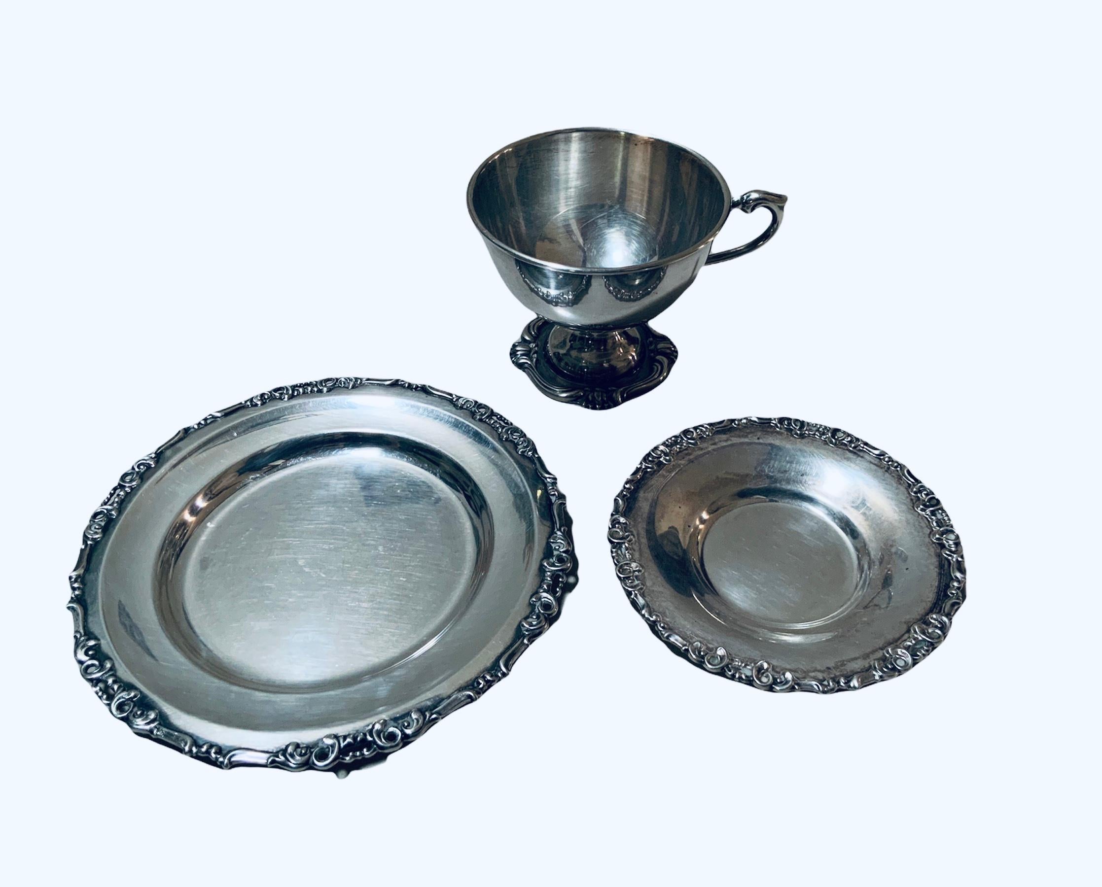This is a set of twelve Camusso 925 sterling cups, saucers and bread/butter or appetizer plates for a total of 36 pieces. The cups are adorned with a repousse of scrolls alternated with water lilies buds in the bottom of their pedestal. Also, their