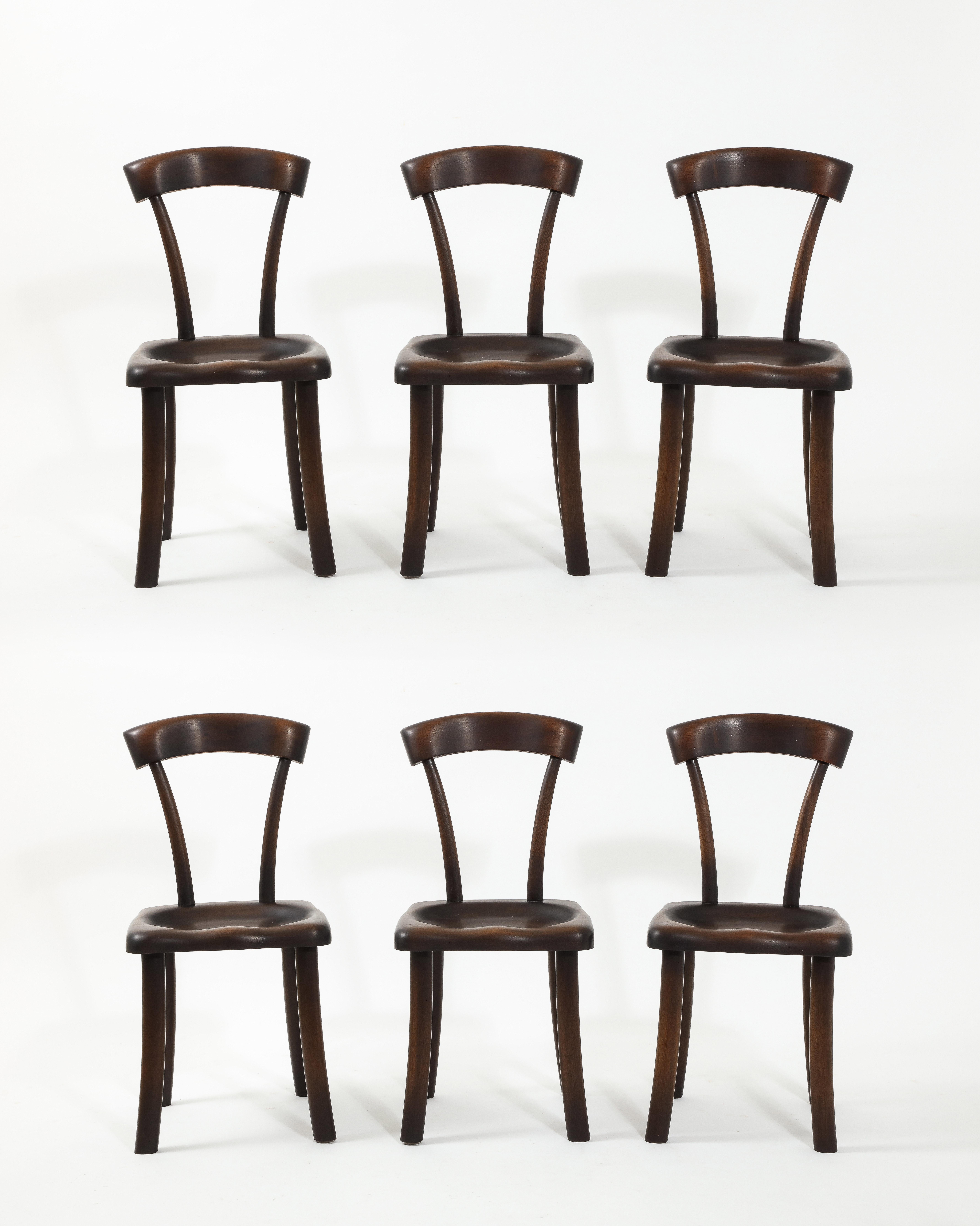 A set of dining chairs in the manner of Alexander Noll, expertly carved out of solid mahogany with a wonderful smokey patina, most likely a commission made in the 90's