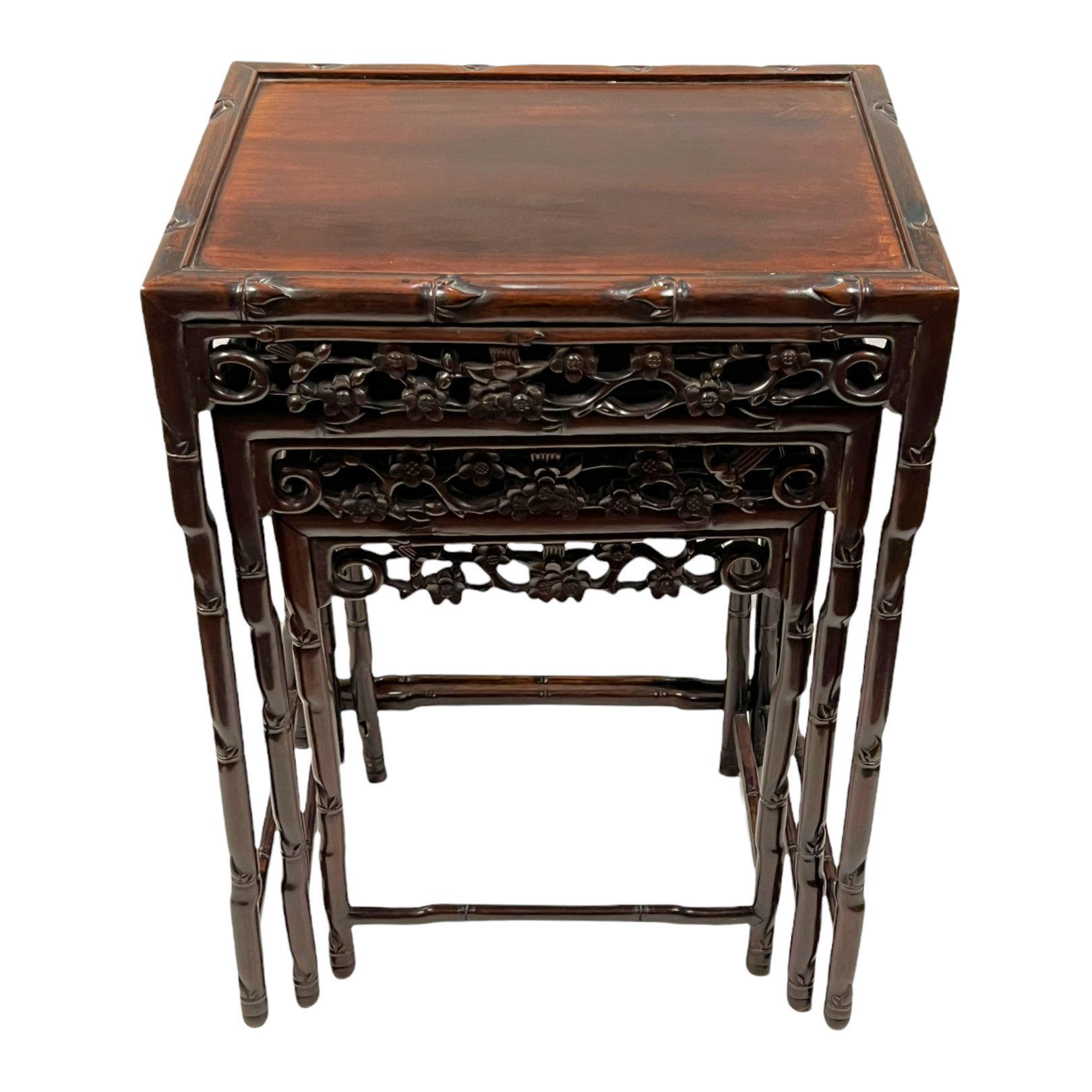 Our set of three nesting tables are exquisitely carved from rosewood and date from the late 19th to early 20th century. With rectangular shaped tops, pierced skirts and bamboo-form legs.
    