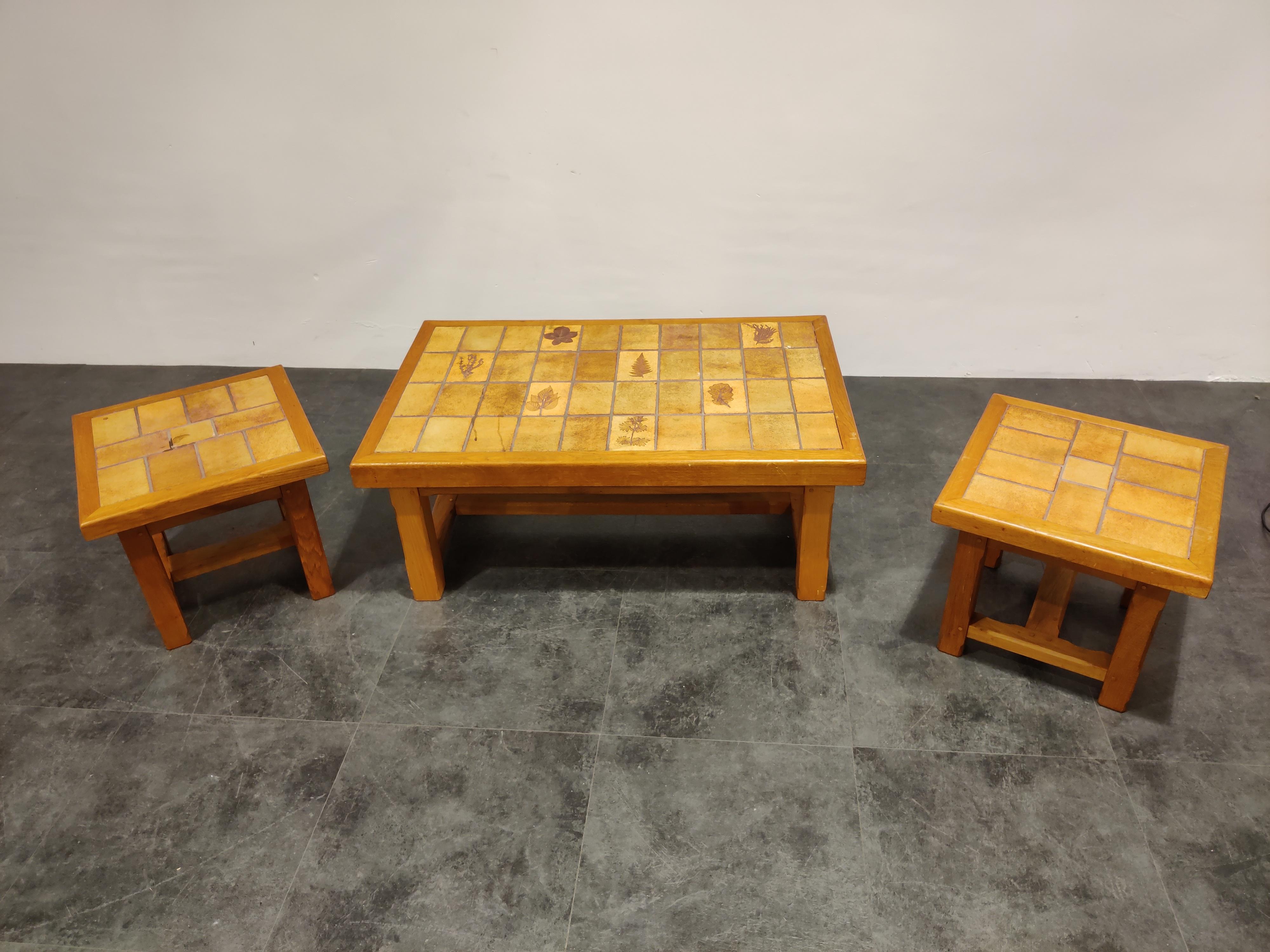 Midcentury coffee table and two side tables with oak frames and earthenware stone table tops in the style of Roger Capron.

Lovely leaf motives 

1960s, France

Condition: Some wear, minor little chips but overall acceptable