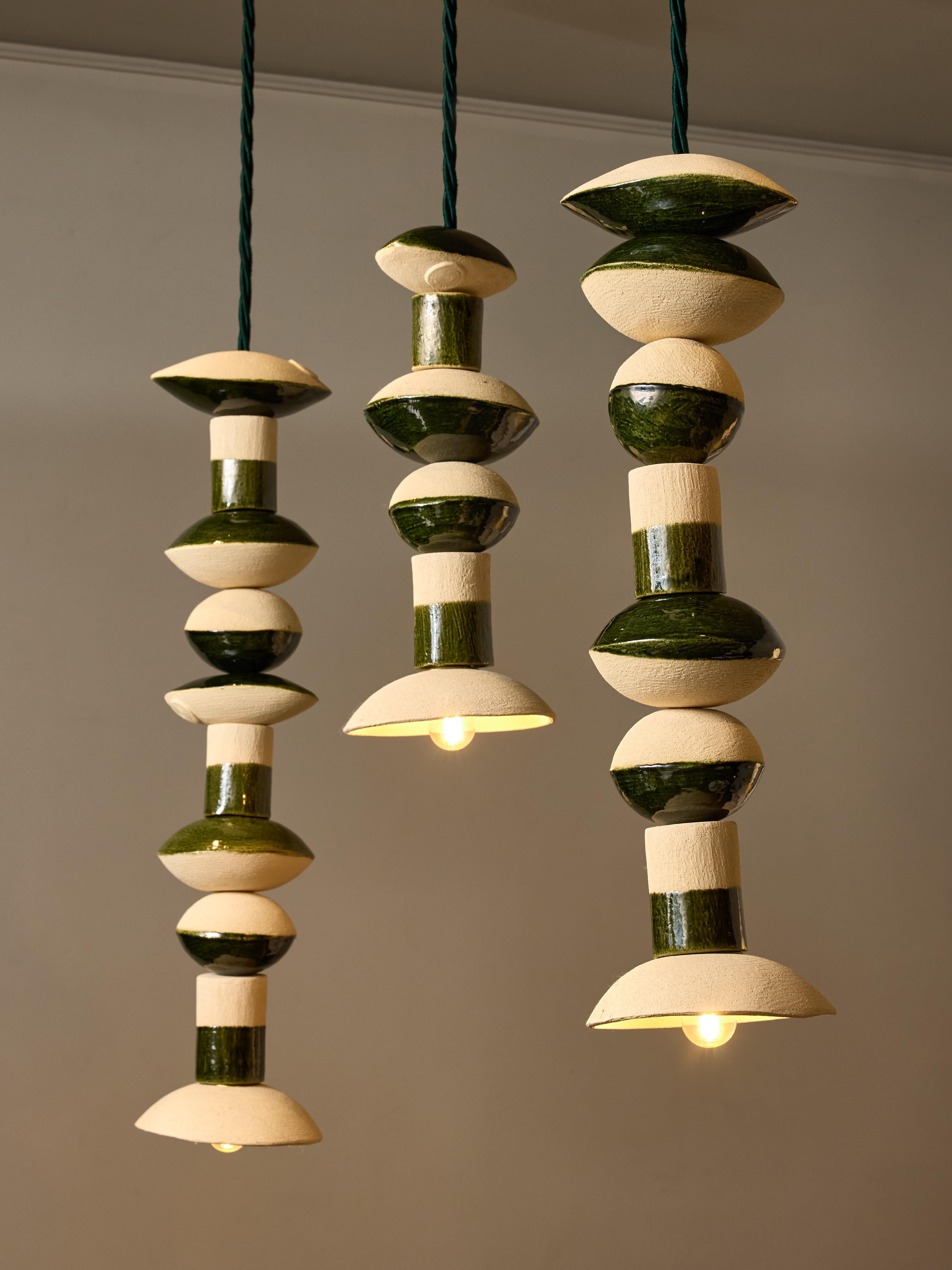 La ceramista Amandine Gorrino, originaria di Marsiglia, ha creato queste sospensioni Perlo impilando su una corda pezzi di ceramica realizzati artigianalmente con uno smalto verde intenso.
Oggi, in qualità di artigiana, Amandine Gorrino ha aperto il