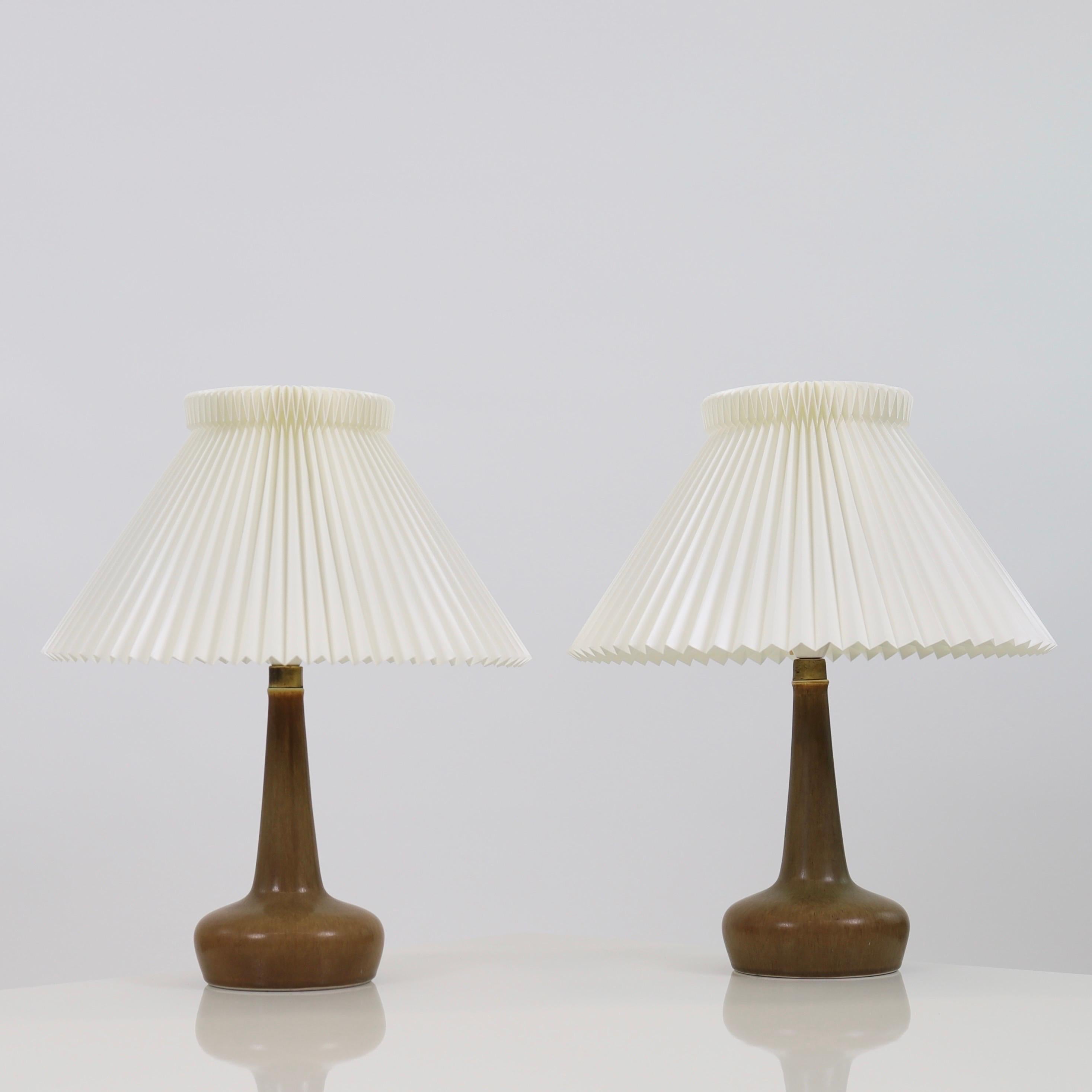 A pair of exquisite ceramic desk lamps designed by Esben Klint for Le Klint in 1949 and produced by Palshus in the 1950s.

* A set of two (2) brown ceramic desk lamps with hand-pleated shades
* Designer: Esben Klint
* Manufacturer: Palshus / Le