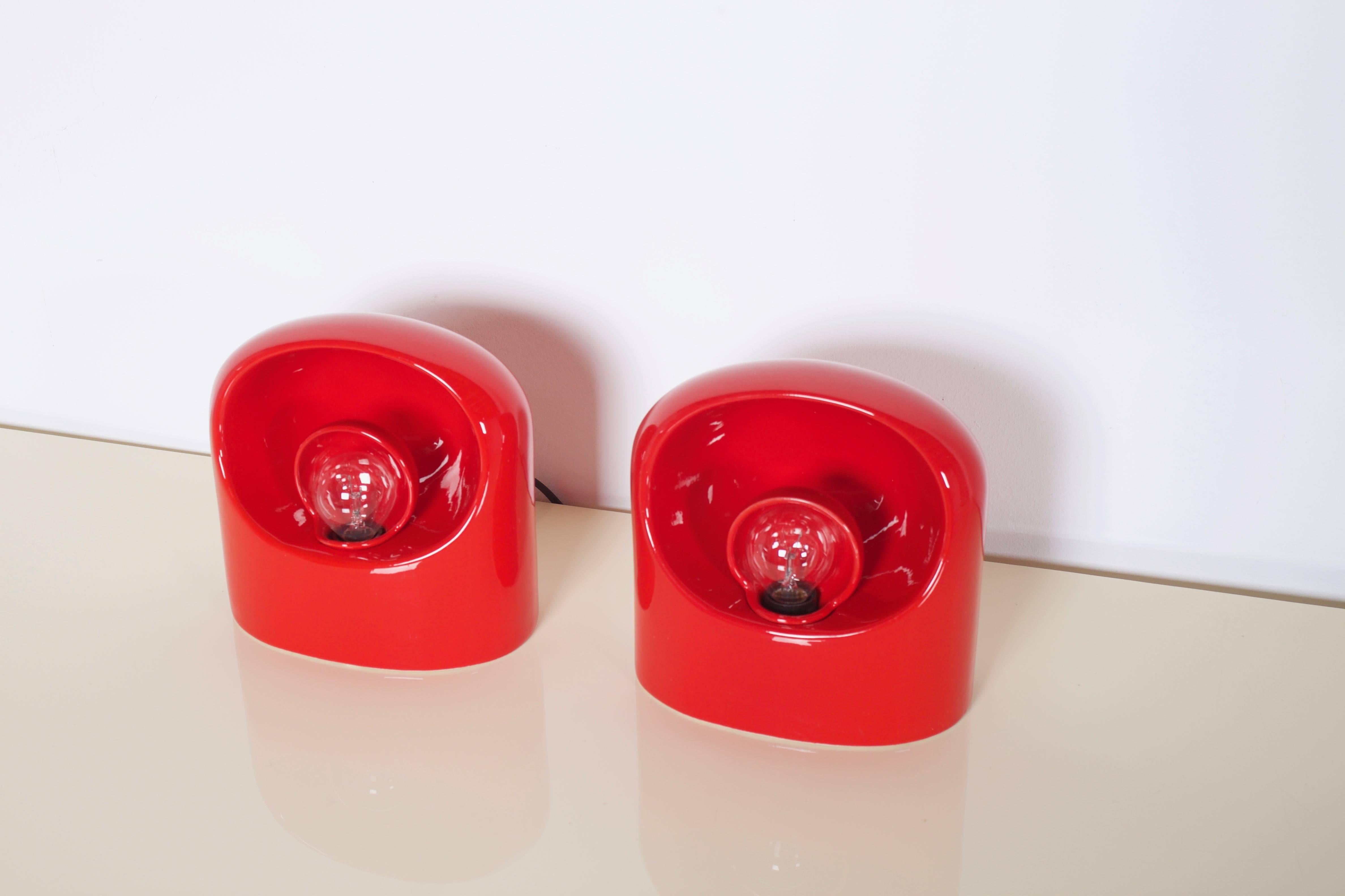 Set of ceramic table lamps by Marcello Cuneo in a beautiful red color. 

 Revolving ceramic shade. 

 Marked on the bottom. 

 These lamps are in great condition.

 