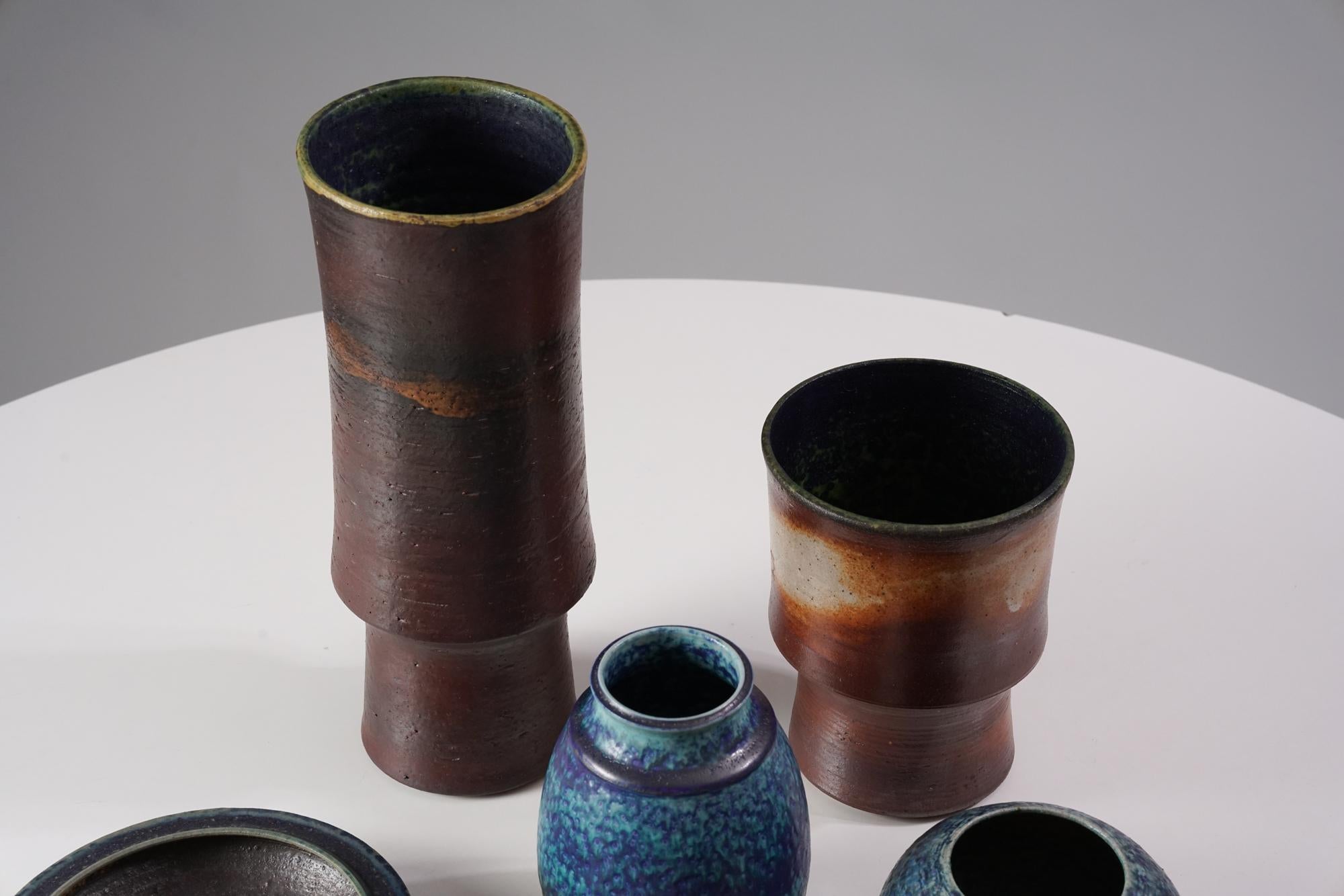 Keramikset von Liisa Hallamaa für Arabia aus den 1960/1970er Jahren. Das Set umfasst drei Vasen, zwei Schalen und zwei kleine Kerzenhalter. Guter Vintage-Zustand, leichte Patina und alters- und gebrauchsbedingte Abnutzung. Die Keramiken werden als