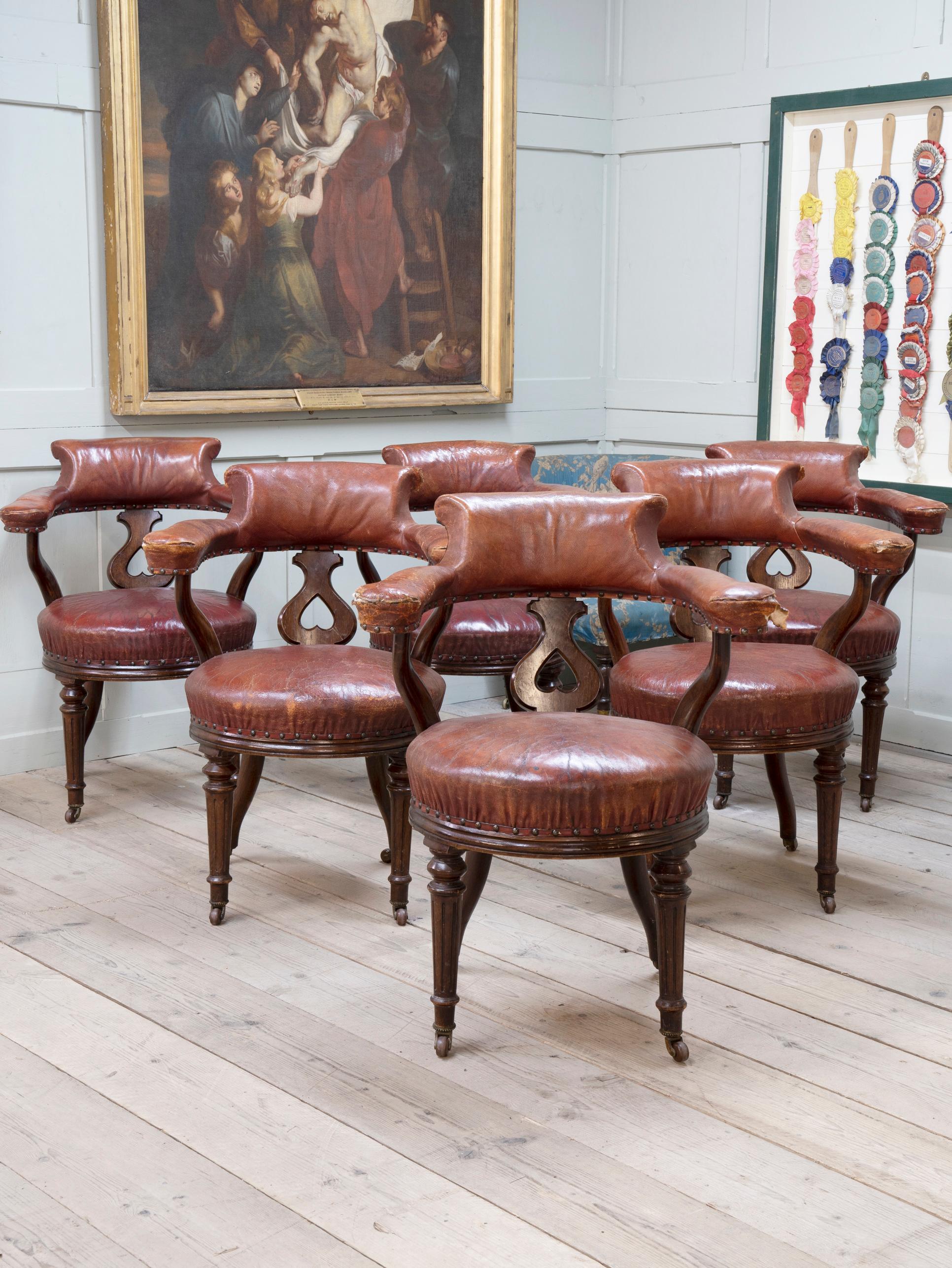 Raised on glazed pot caster with turned tapering oak legs, Moroccan leather button seat, upholstered back and arm rest supported on heart motif back splat.

Highly original examples.