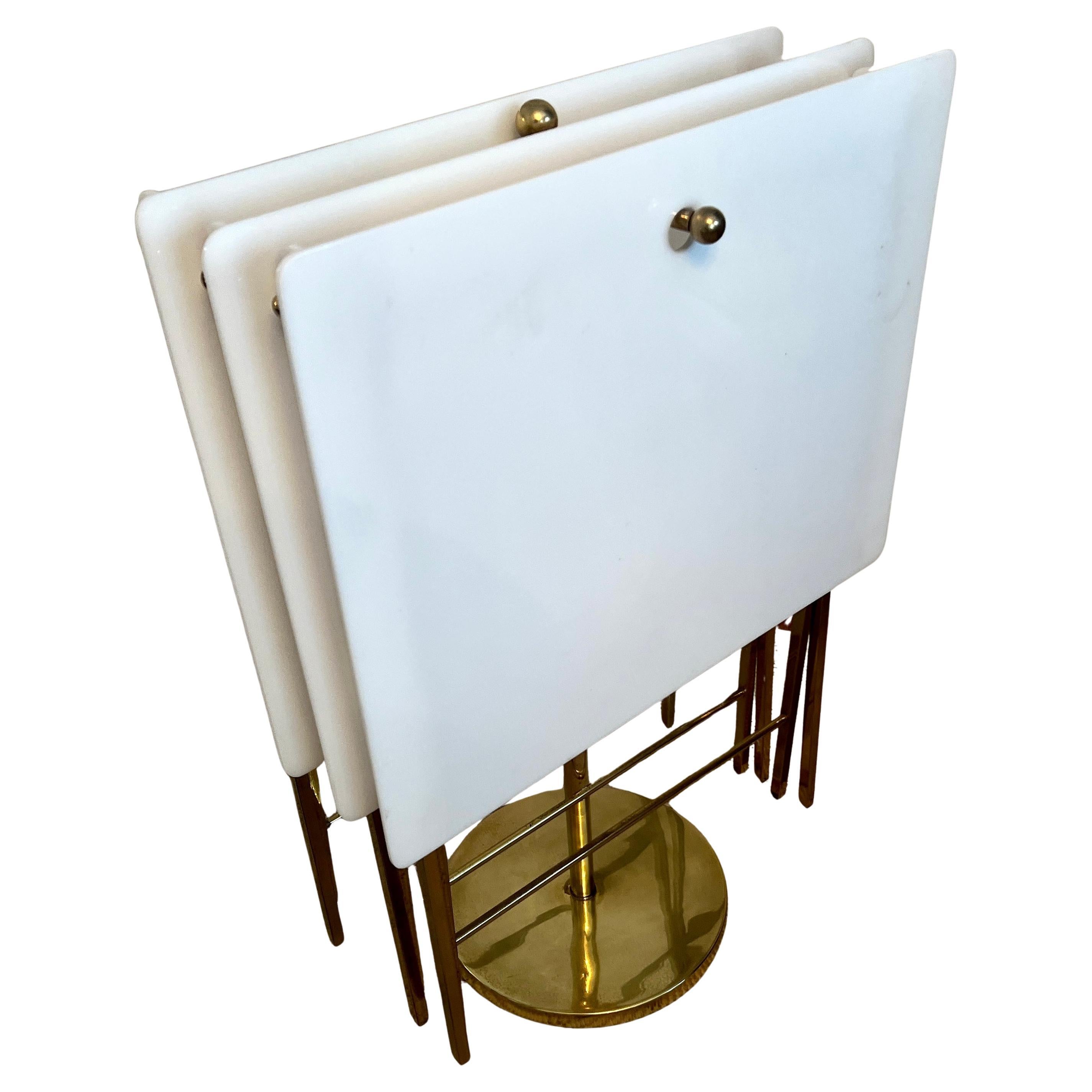 Conjunto de mesas bandeja plegables de acrílico blanco con estructura y patas de latón, del diseñador de mediados de siglo Charles Hollis Jones.  La necesidad de una mesa bandeja es bastante frecuente.  Ya sea que estés entreteniendo a un grupo de