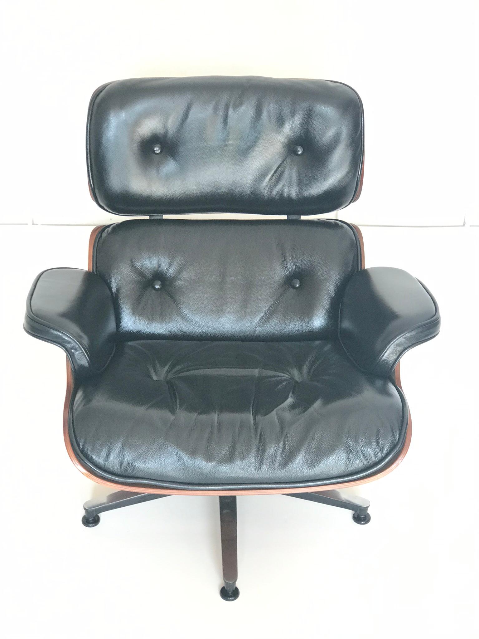 Edition Herman Miller. The chair and the ottoman is in a very good condition. Nuts wood and black leather in the original patina.