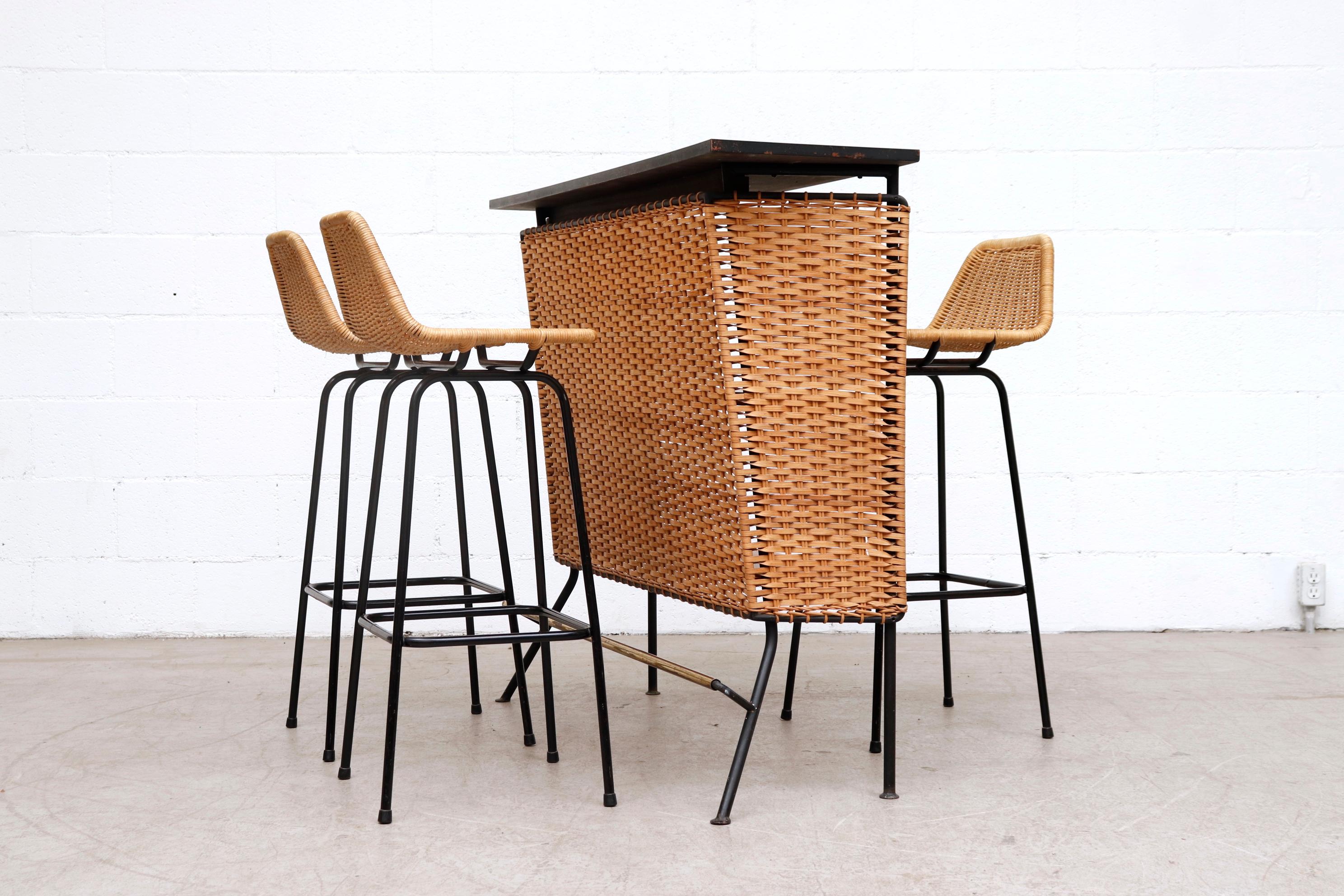 Set of 3 Charlotte Perriand style tall angle backed rattan bar stools by Dirk van Sliedregt with black enameled tubular frame rattan woven seating with light patina. Shown with Weinberg style rattan bar, Listing #LU922419075692. In original