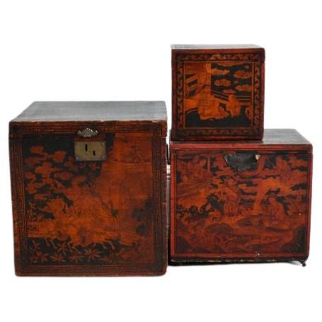 Chinesische rot-schwarze Schachteln, 20. Jahrhundert.

Satz von drei chinesischen roten und schwarzen Schachteln, verziert mit Figurenszenen in Landschaften mit Tempeln und Pavillons. 

Holz, möglicherweise Kiefer, Farbe und Metall.