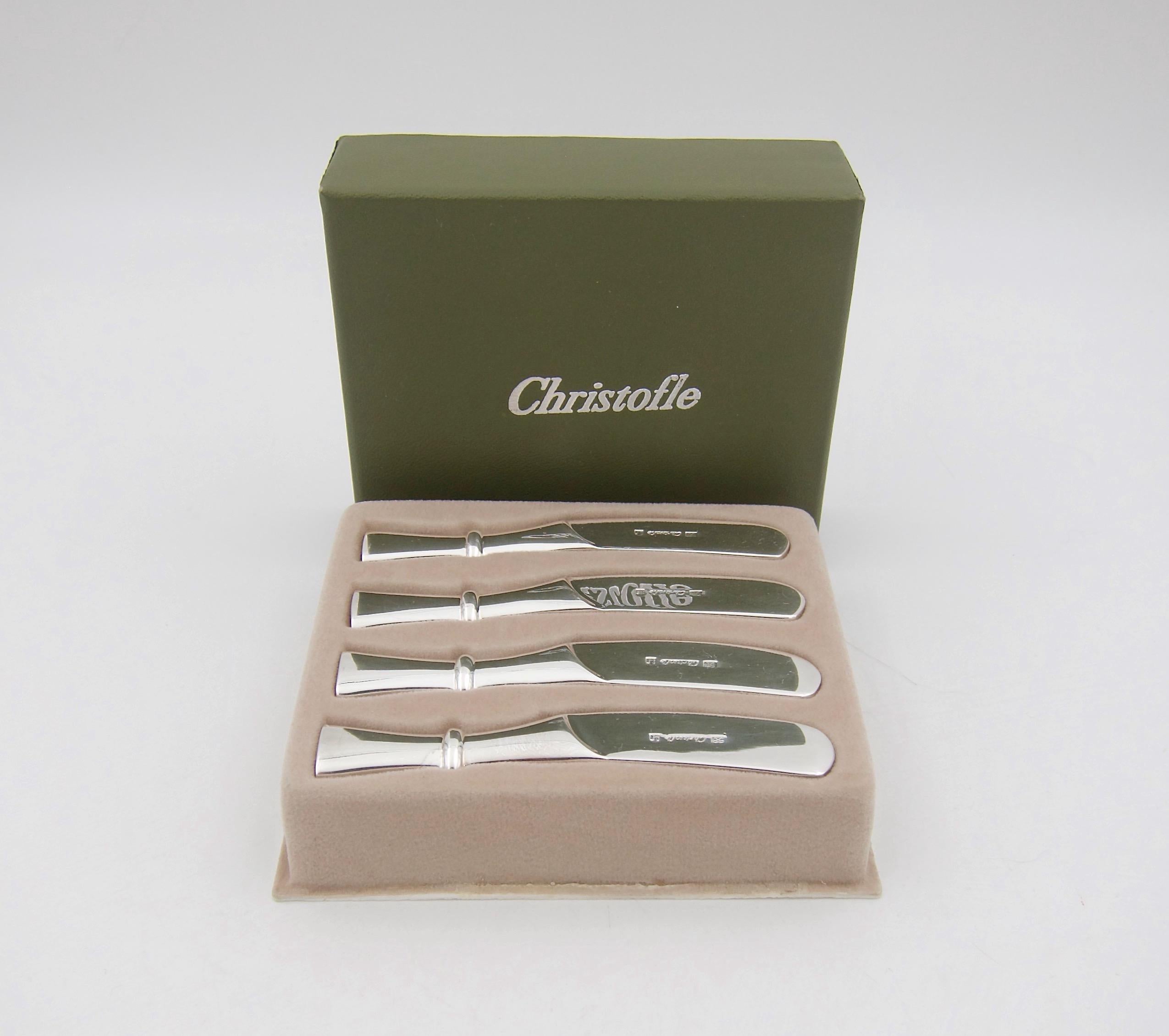 A boxed set of four babylone butter spreader knives in polished silverplate with solid handles from Christofle of Paris. The pattern is called 