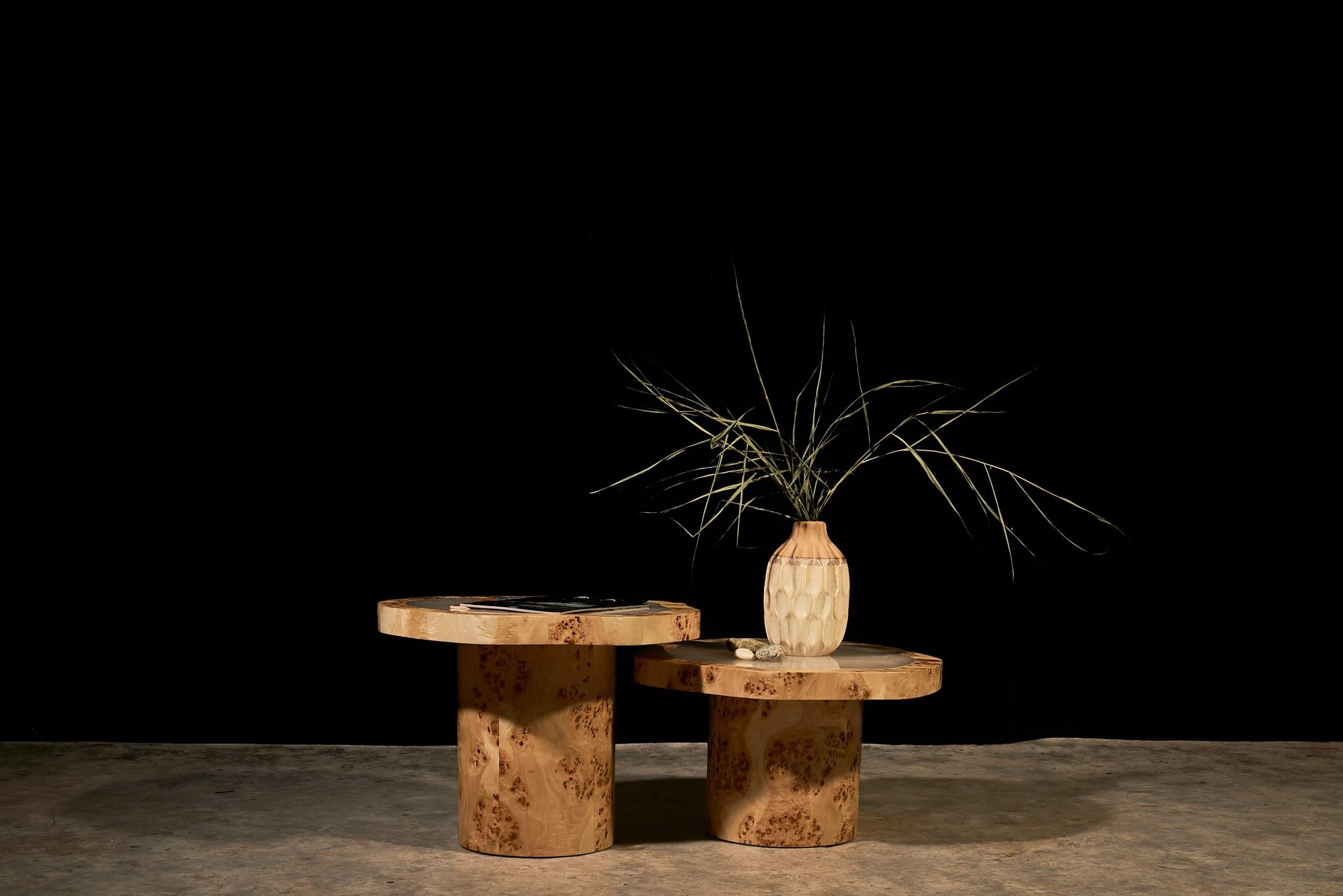 Cet ensemble de deux tables basses a été fabriqué à la main dans l'atelier de VulpeConcept. Chaque plateau est en placage de loupe de peuplier naturel aux veines soigneusement alignées, centré par une plaque incrustée d'onyx poli qui offre une douce