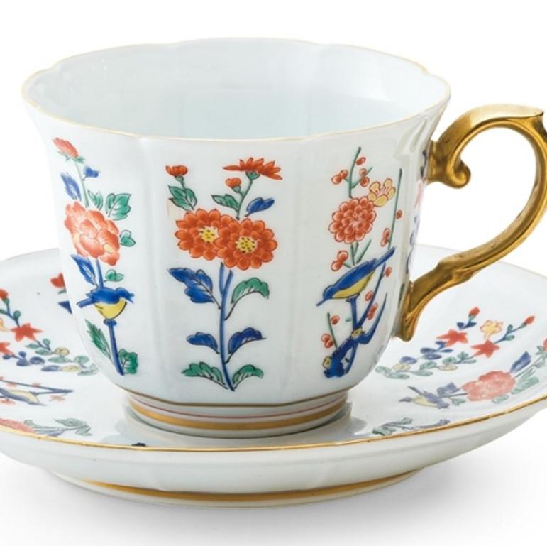 Exquise tasse et soucoupe contemporaines en porcelaine Imari peinte à la main et dorée, de couleur rouge vif, bleue et verte, généreusement décorée d'or. Le motif de ce superbe ensemble, festonné autour du bord de la tasse et de la soucoupe, est