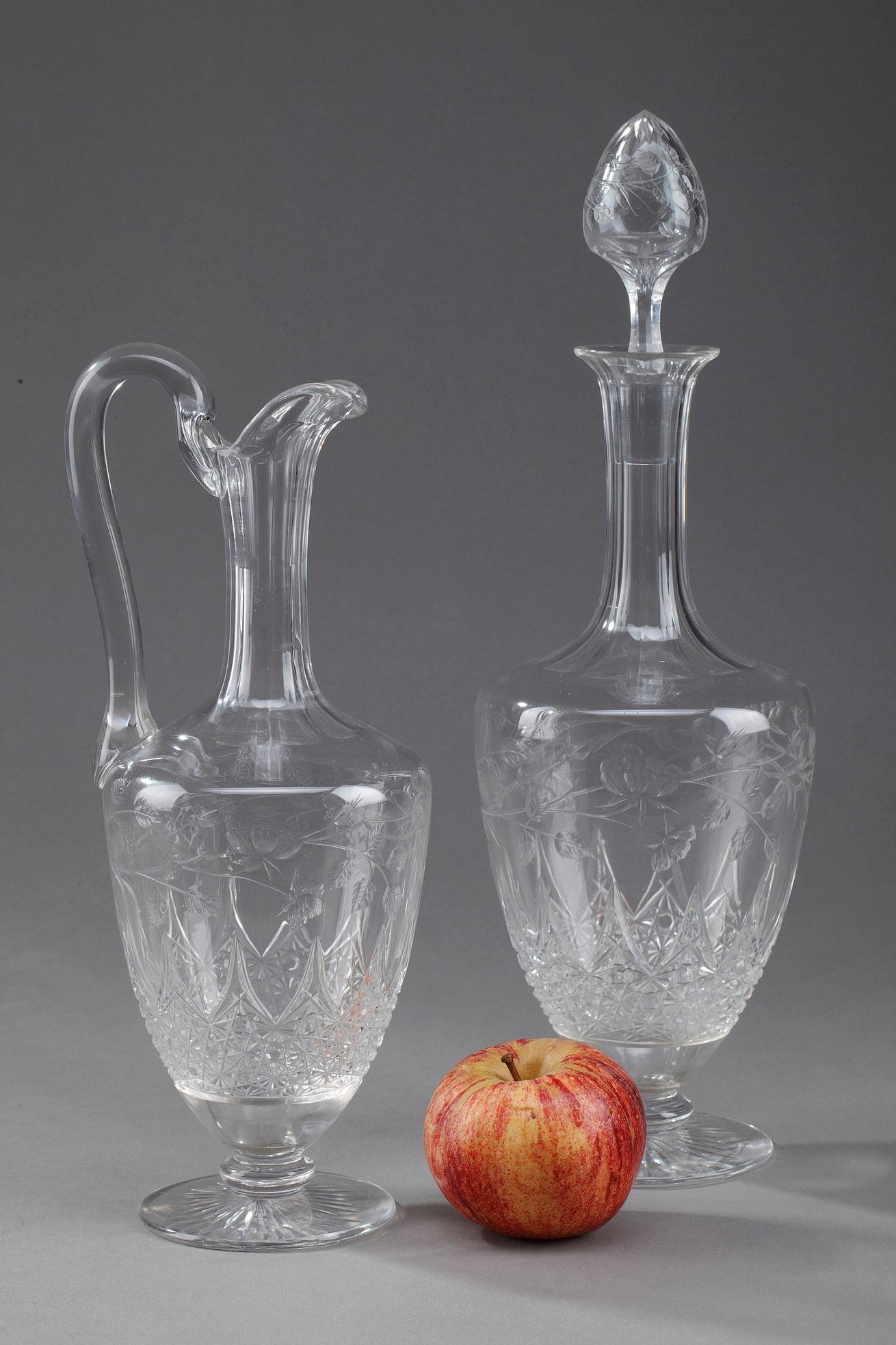 Set composed of a ewer and a carafe in cut crystal. The upper part of the sides and the stoppers are decorated with patterns of chiseled foliage and flowers while the lower part is cut in diamond points. The foot is decorated with a star on the