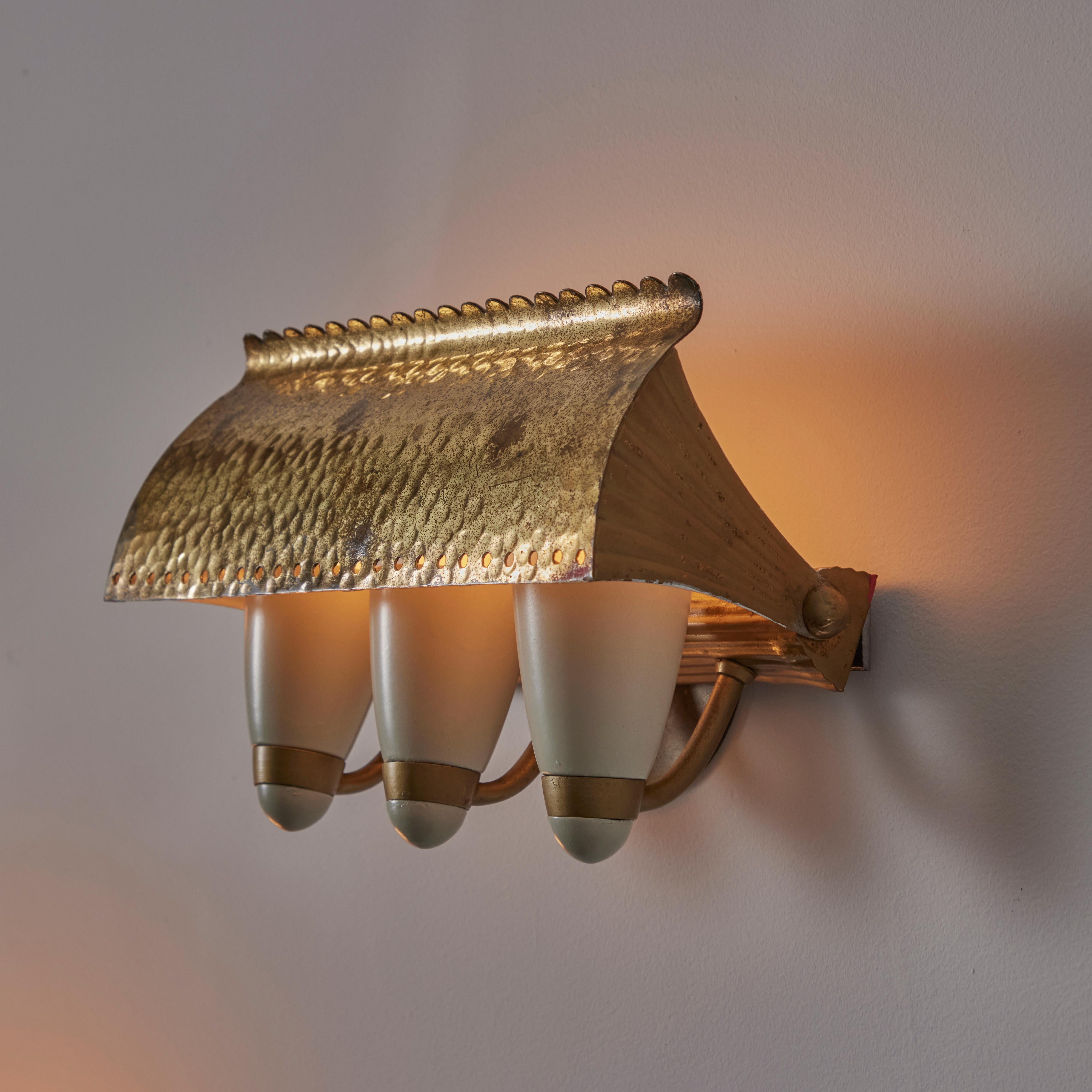 Custom sconces by G.C.M.E. Designed and manufactured in Italy, circa the 1940s. Three cone shaped lights are masked by a beautiful scallop lipped shade. The shade can pivot up and down, allowing the user to play with light direction and exposure of