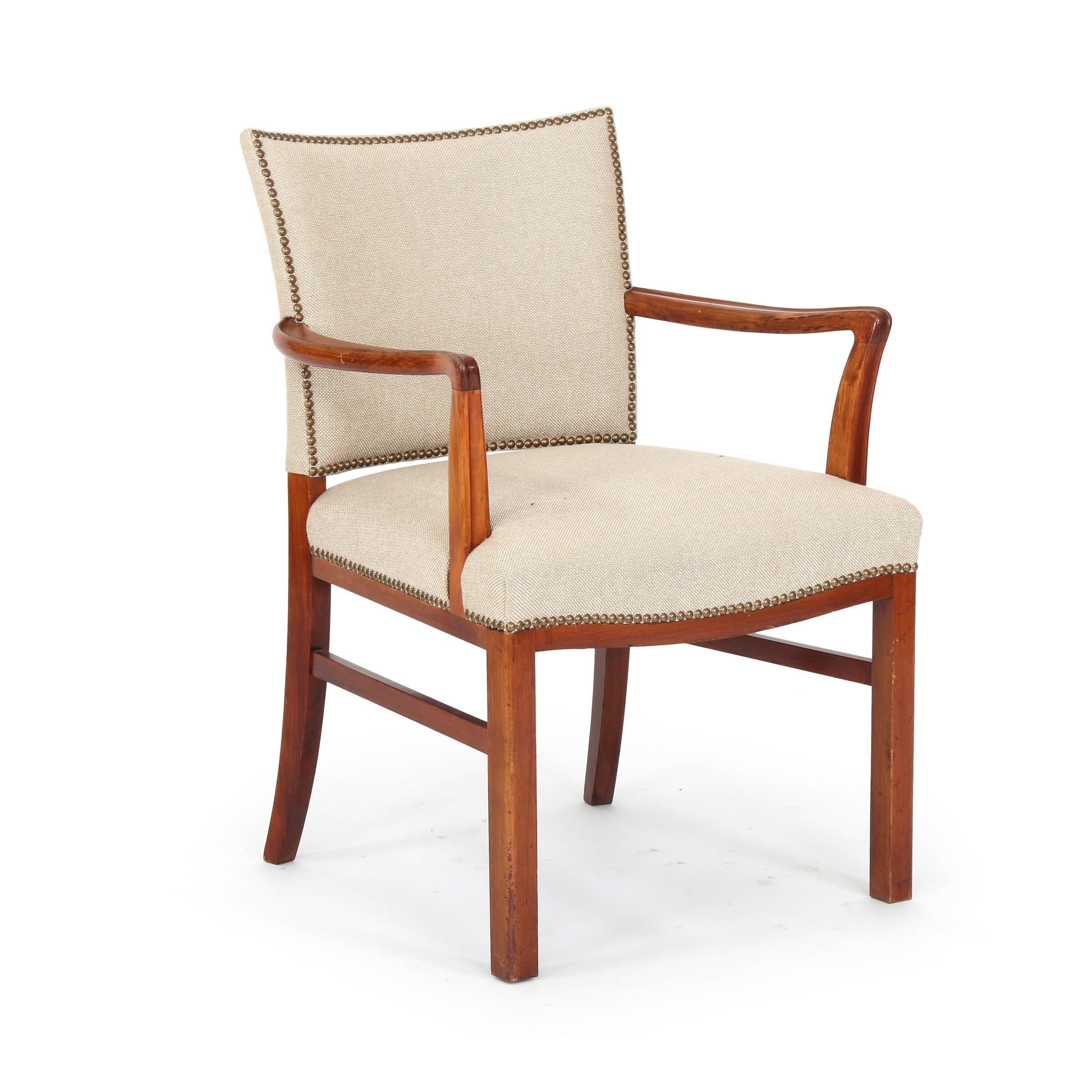 A set of Danish mahogany dining chairs comprised of four side chairs and two armchairs in the manner of Kaare Klint attributed to Jacob Kjaer. The chairs reupolstered in a oatmeal colored wool fabric with close-nailed decoration, circa 1940s. Side