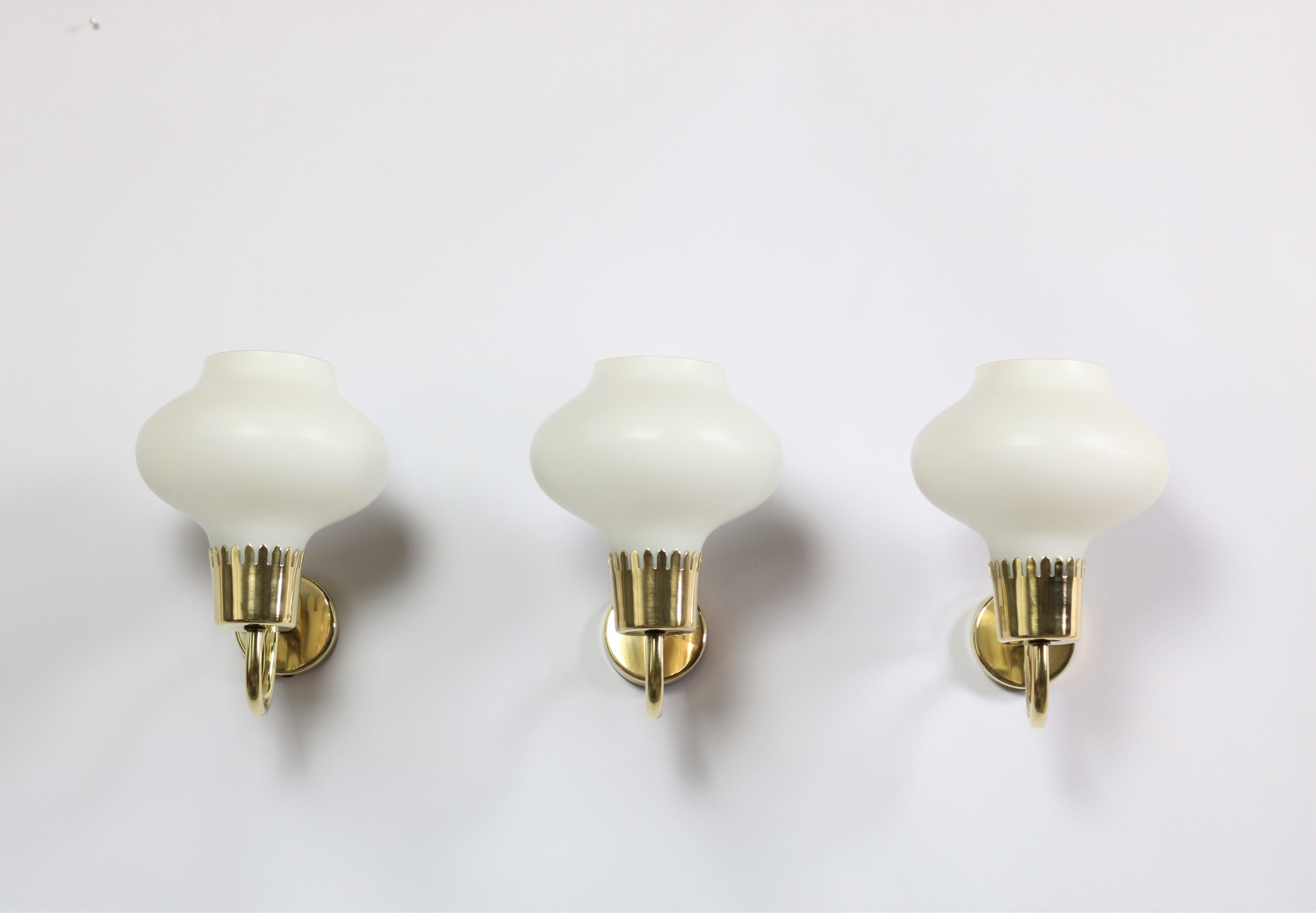 Beautiful set of three wall sconces in mouth-blown opal glass and solid brass. Produced by Fog & Morup in Denmark in the 1950s and designed by architect Acton Bjorn. Bjorn collaborated with Vilhelm Lauritzen in the 1930-1940 and the influence from