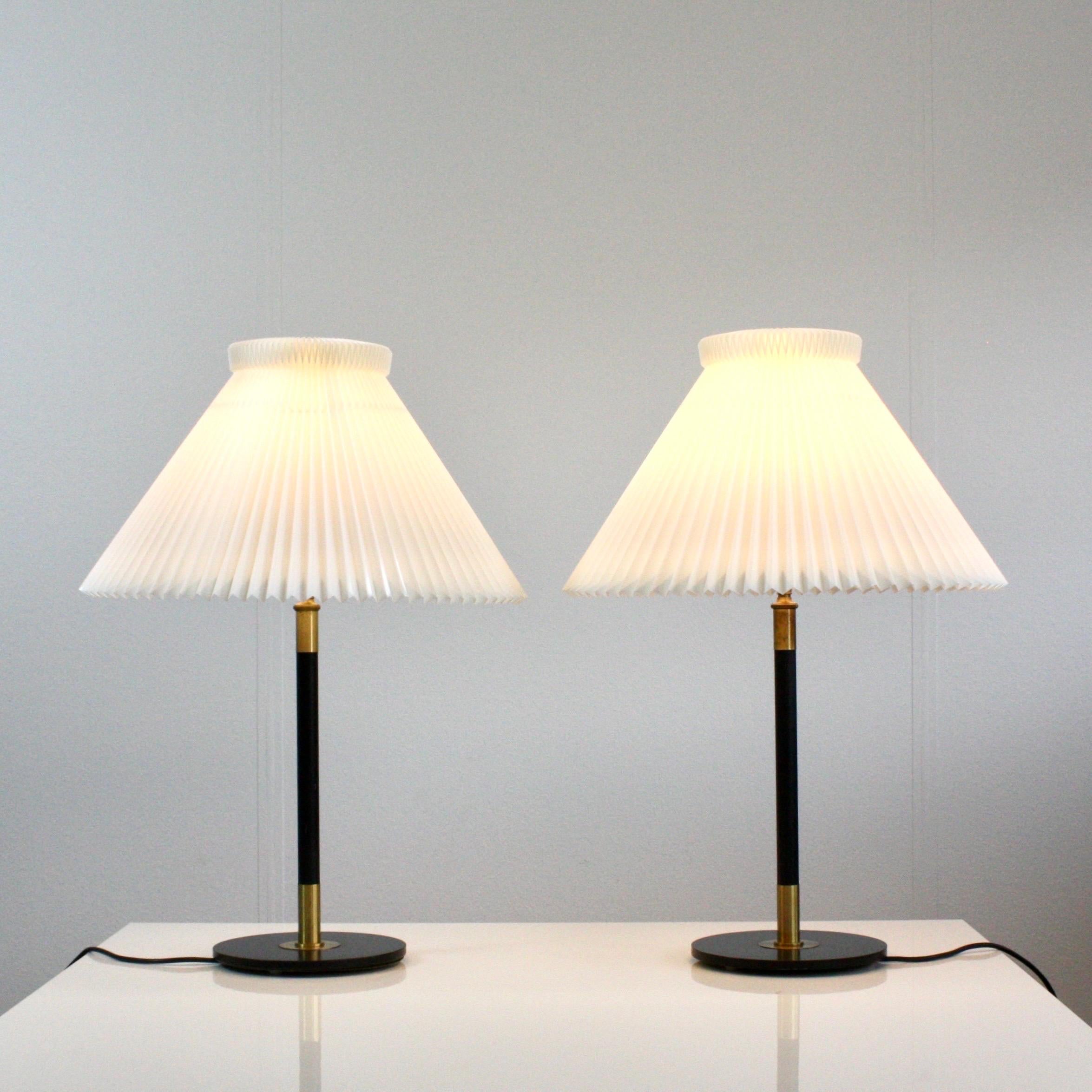 A pair of table lamps designed by Aage Petersen for Le Klint in 1950 featuring black metal bases and the classic white Le Klint shades. The set is in very fine  vintage condition.

* A pair of black table lamps with brass details and hand-pleaded