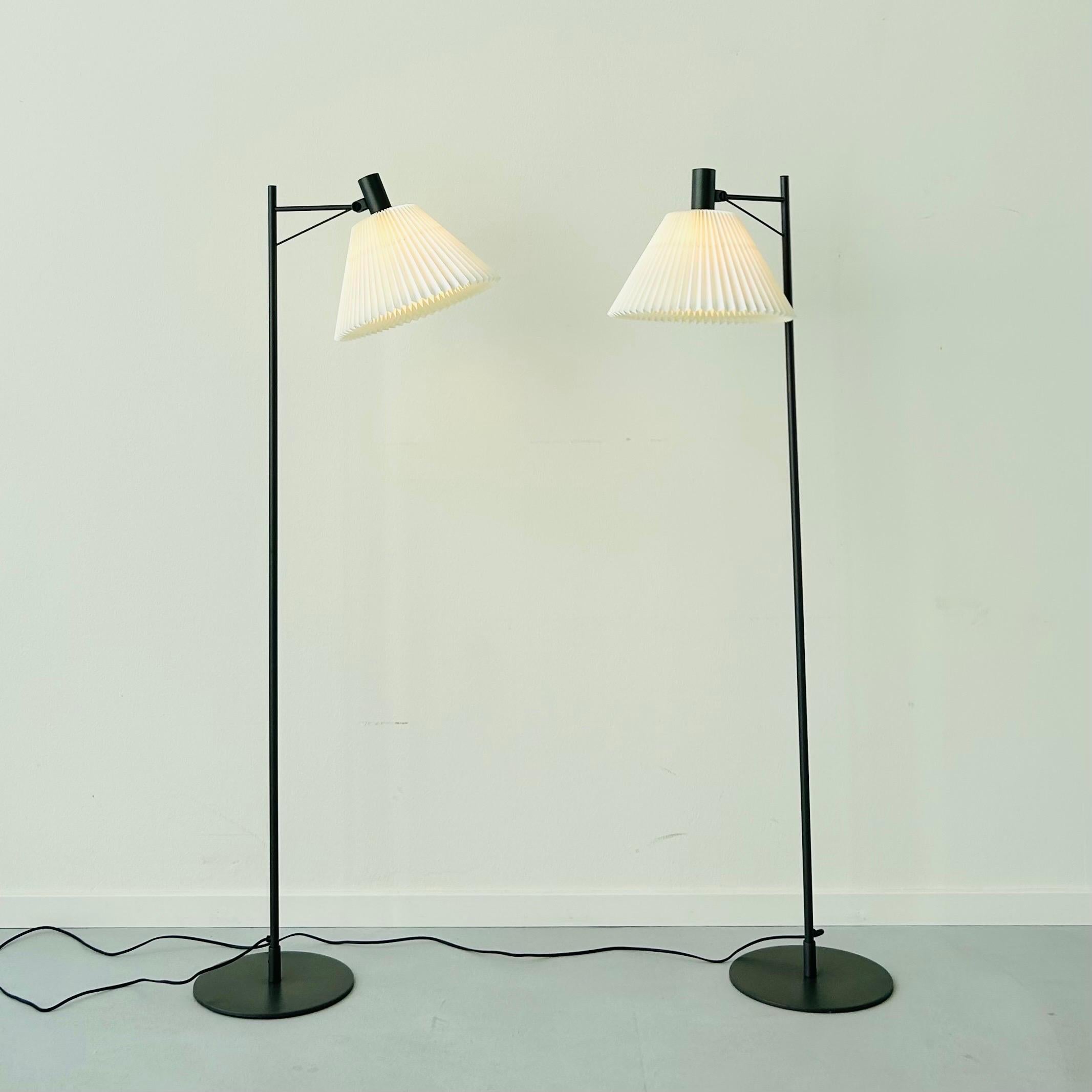 A set of classic straight-line Le Klint 372 floor lamps designed by Flemming Agger in the 1970s. They have practically no marks and come with never-used shades. 

* A set of antricit gray metal floor lamps with a white hand-pleated shade
* Designer: